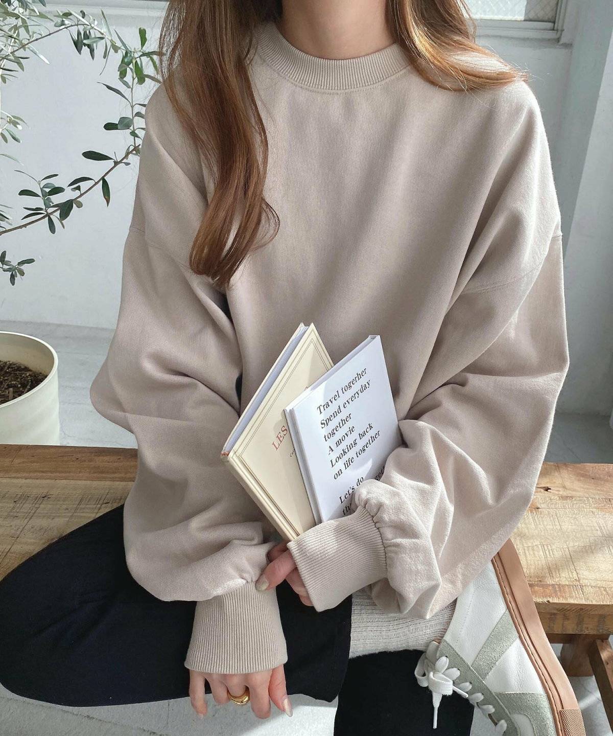 ベージュのスウェットに黒デニムを合わせた女性