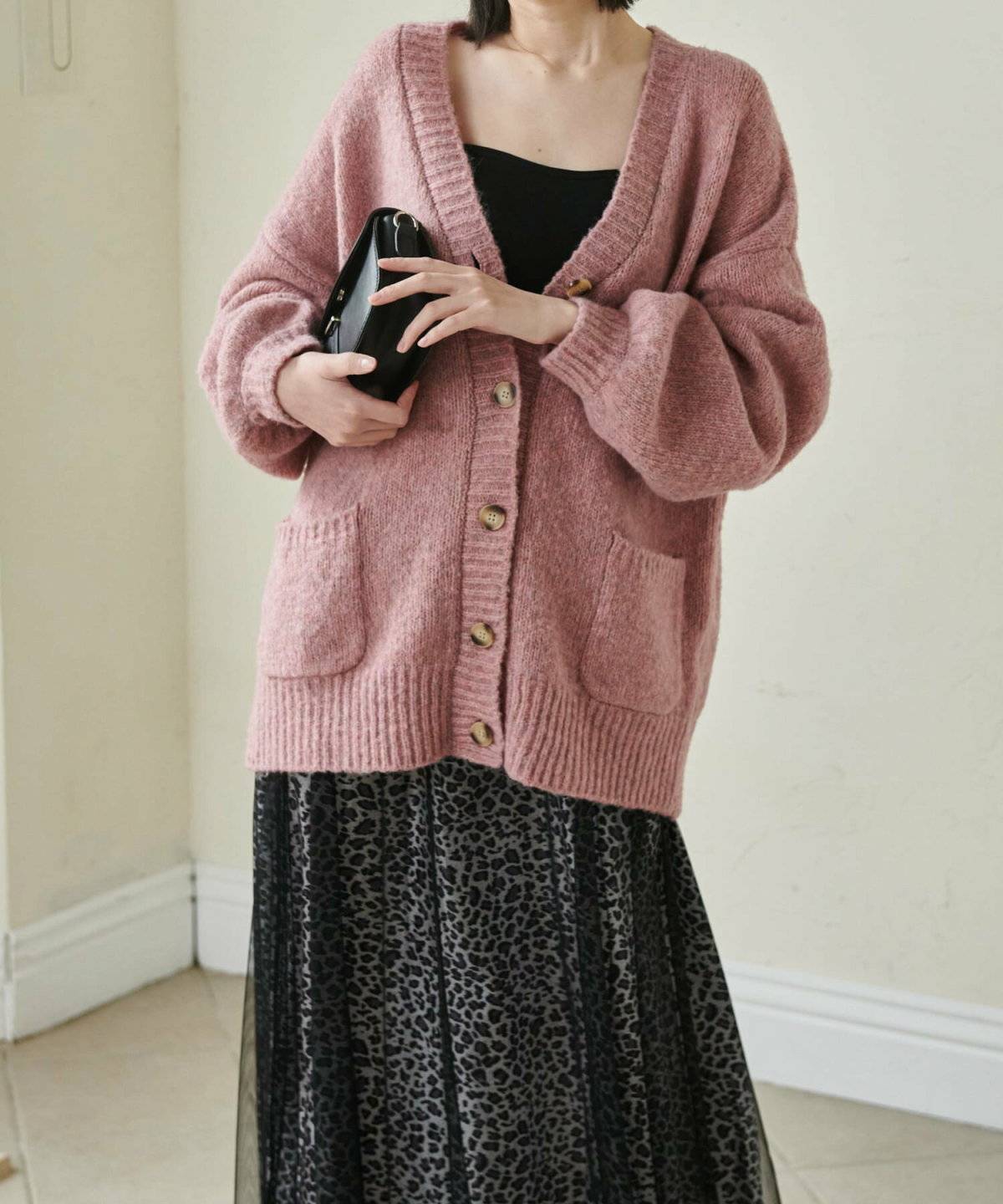 カラーカーディガンに黒スカートを合わせた女性