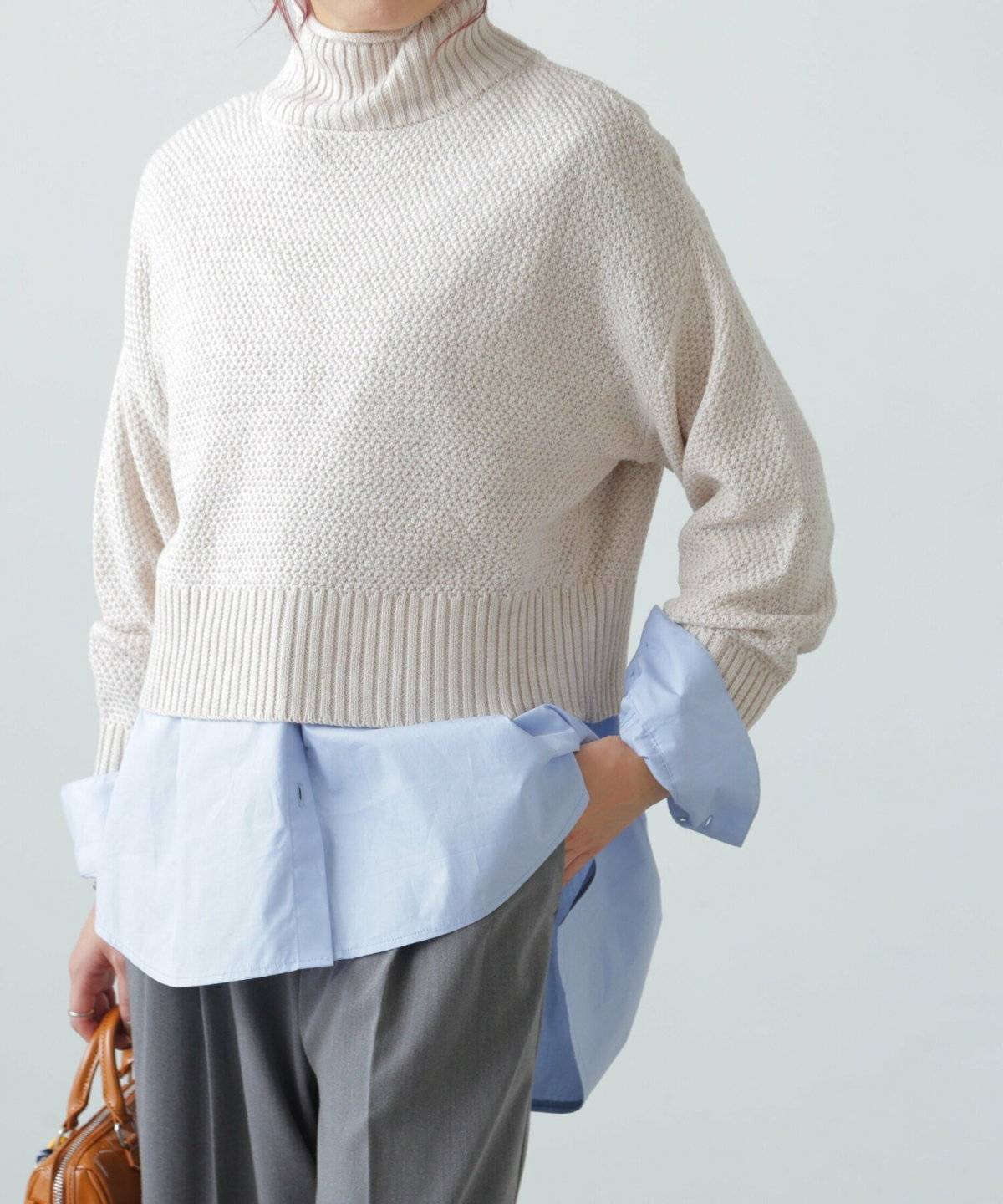 ニットとシャツを重ねてパンツを合わせた女性