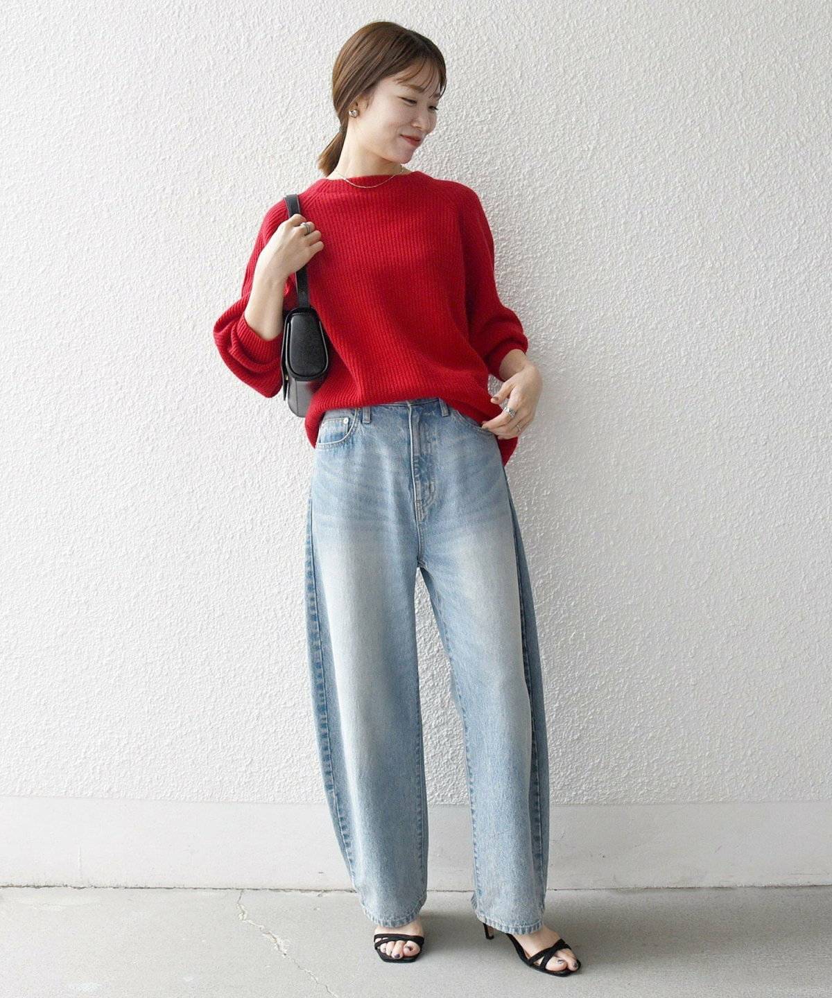 赤ニットにデニムを合わせた女性