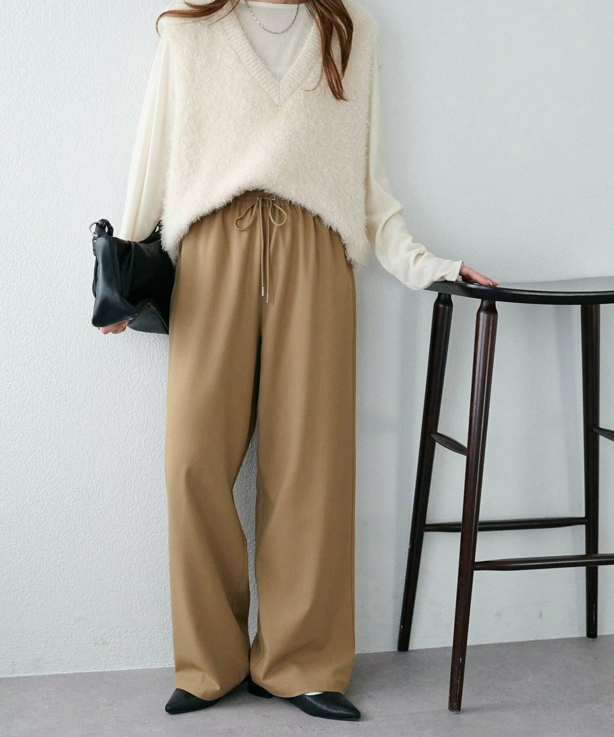 白ニットにベージュパンツを合わせた女性
