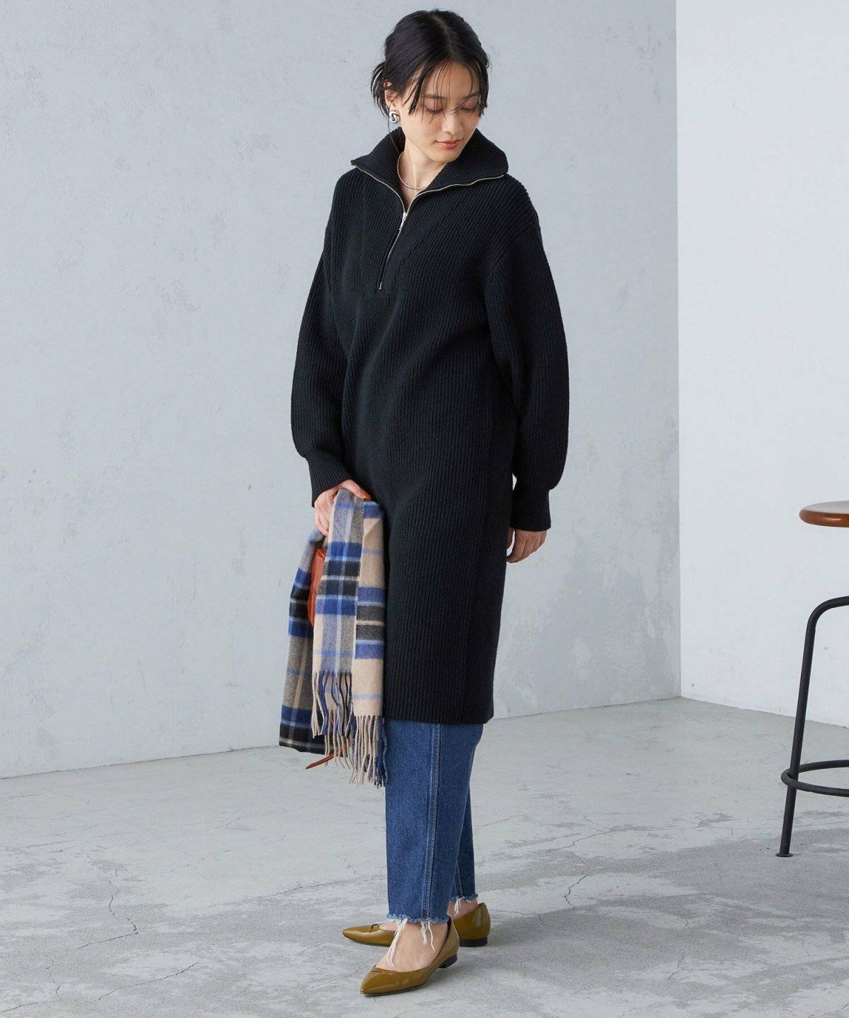 ニットワンピースにデニムを重ねた女性