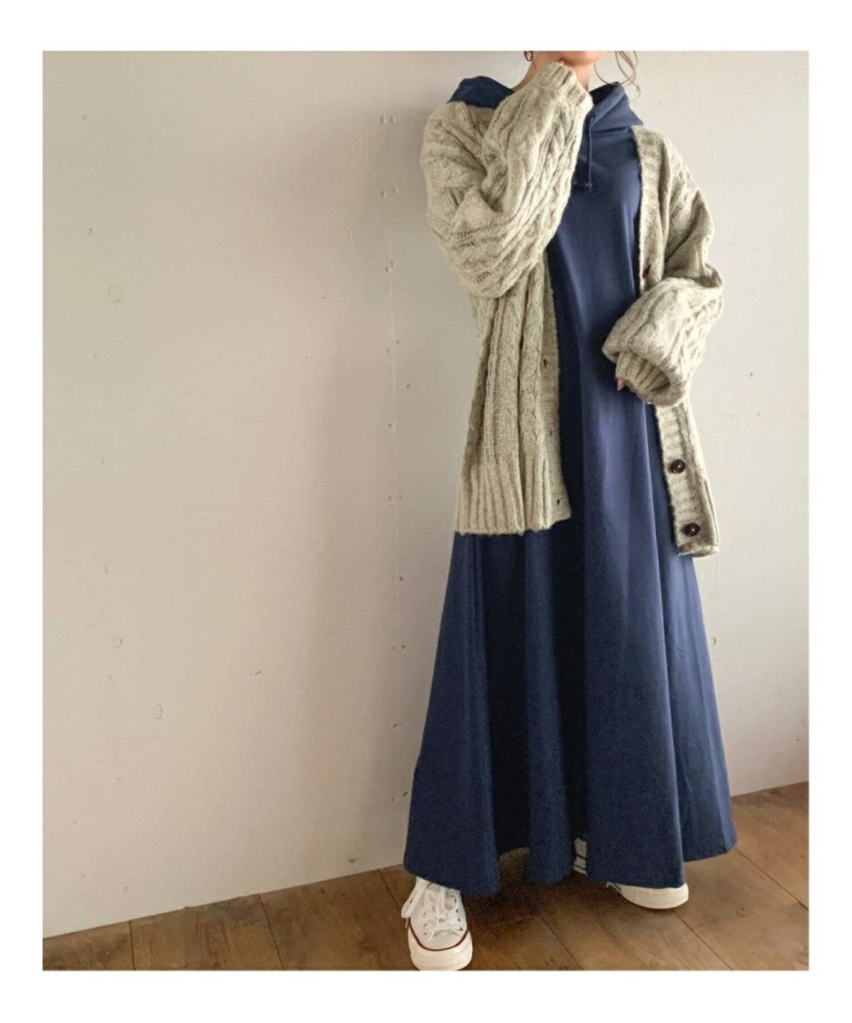 ネイビーのパーカーワンピースを着た女性