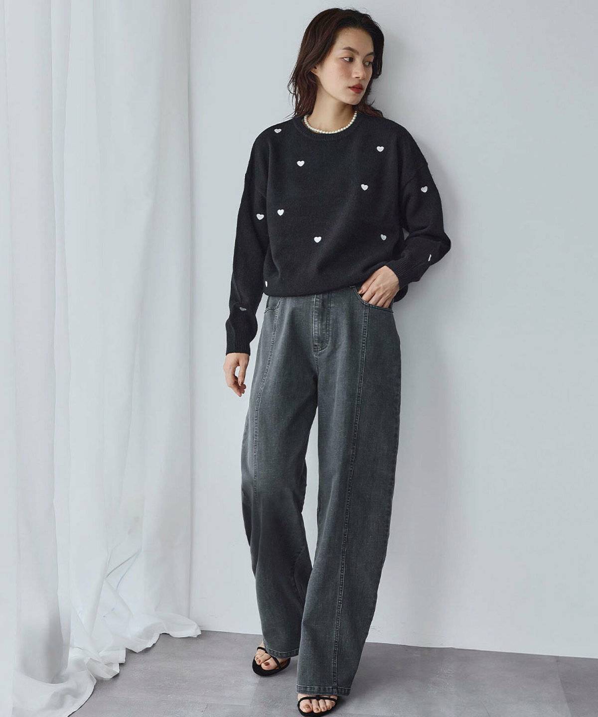 ハート柄ニットにデニムを合わせた女性