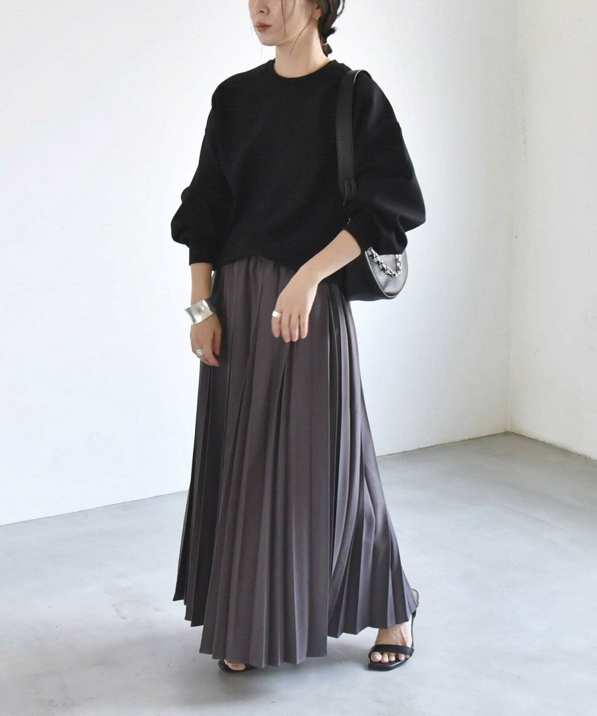 スウェットにプリーツスカートを合わせた女性