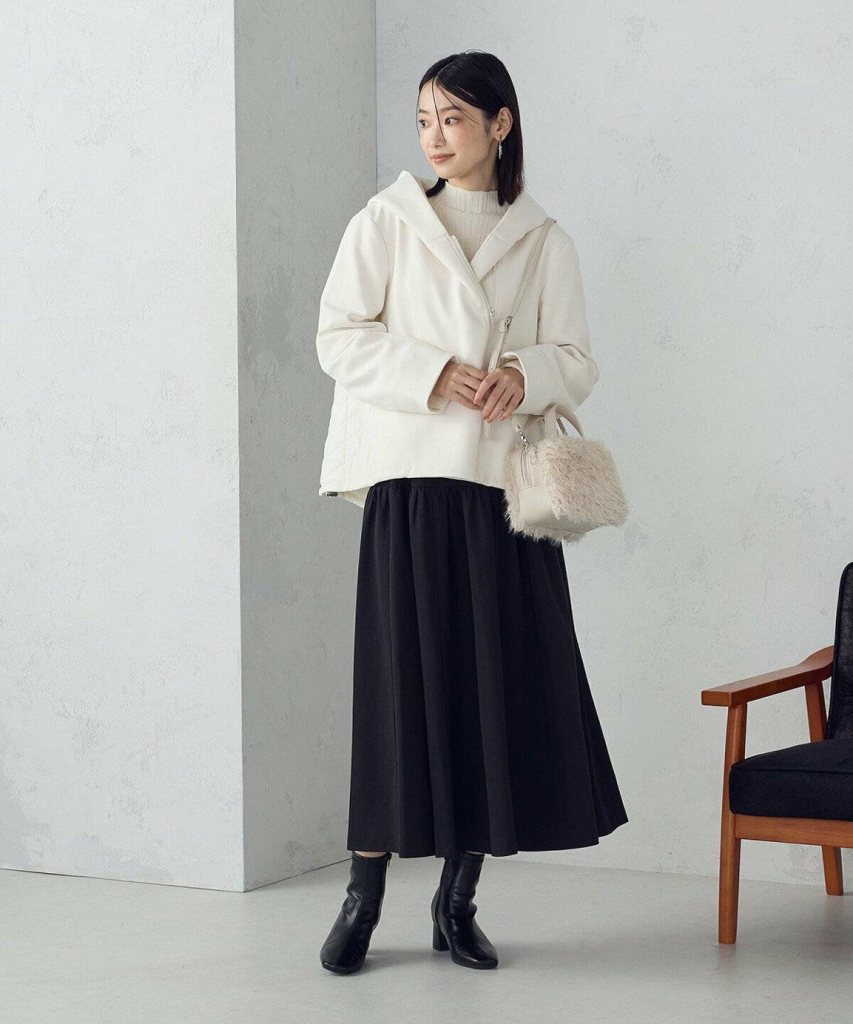 ブルゾンを羽織って黒スカートを合わせた女性