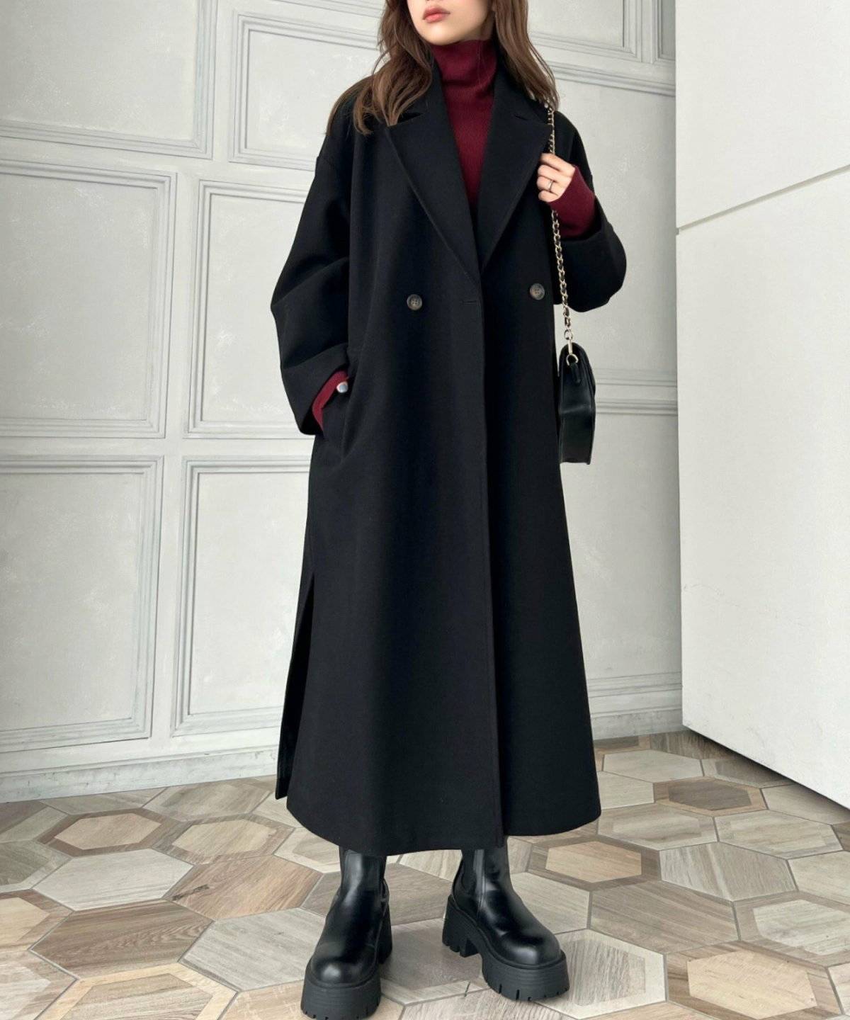 黒コートに赤ニットを合わせた女性