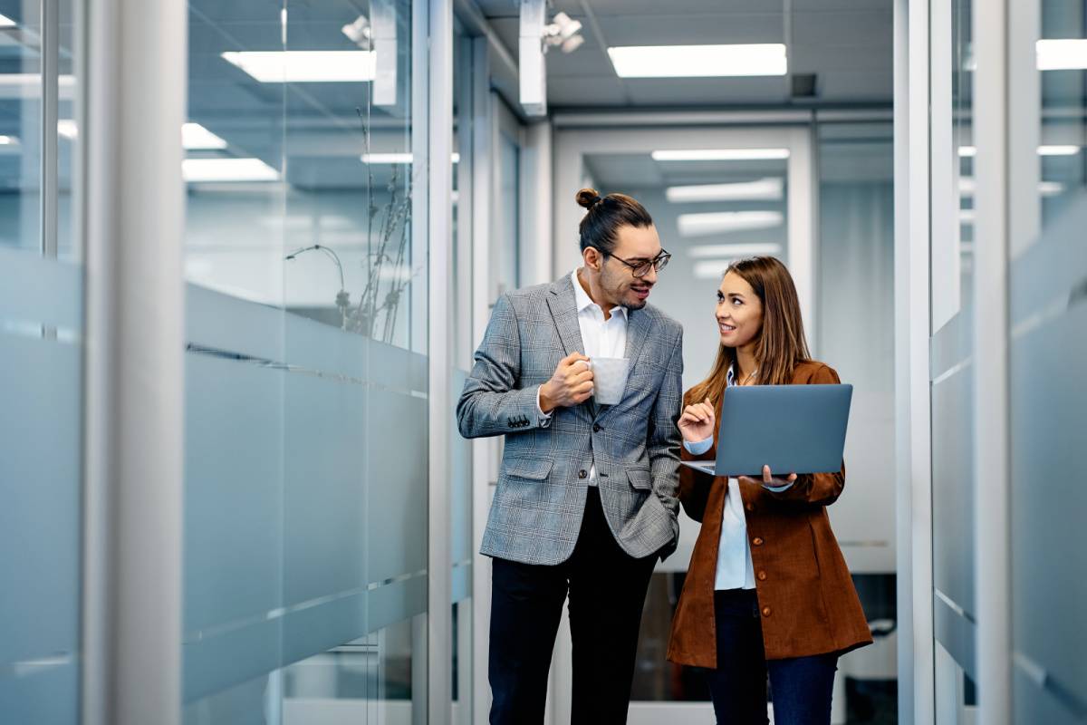 オフィスの廊下を歩きながら話す男女