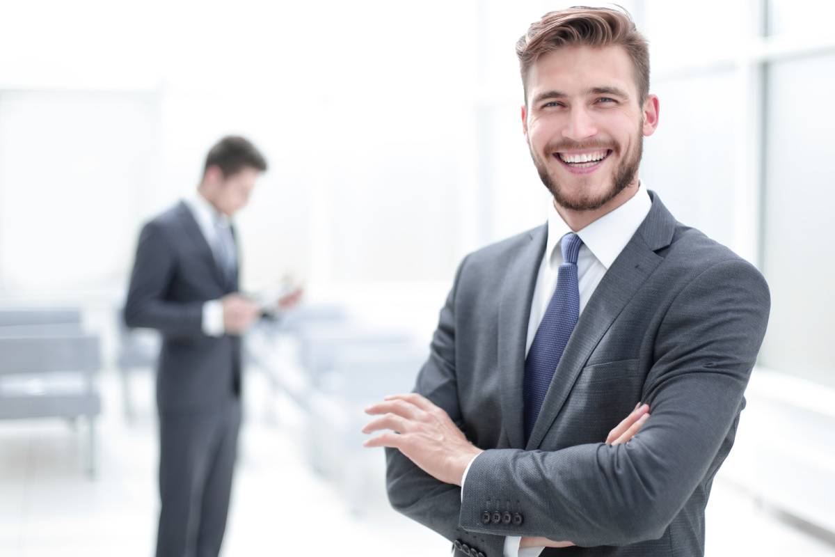 腕組みして立つ笑顔の男性