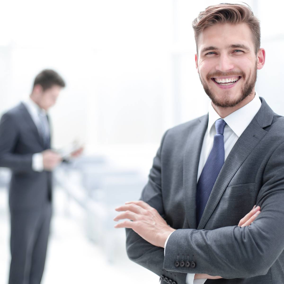 腕組みして立つ笑顔の男性