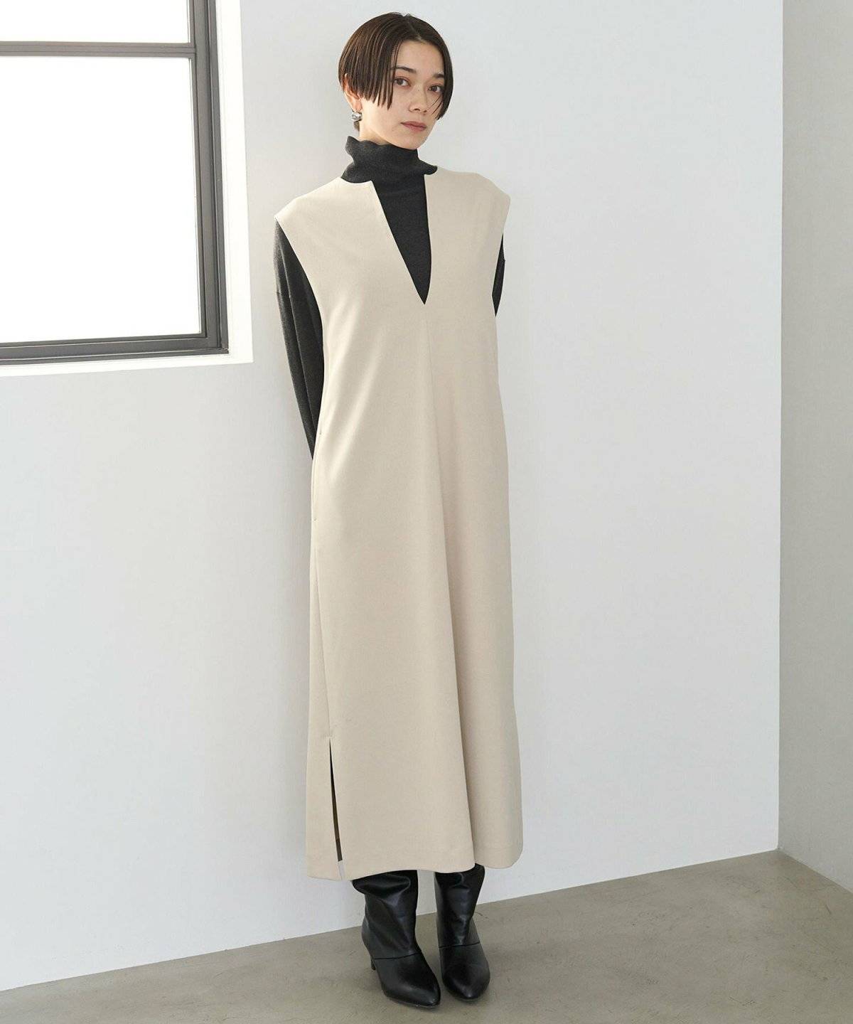 ワンピースにハイネックトップスを重ねた女性