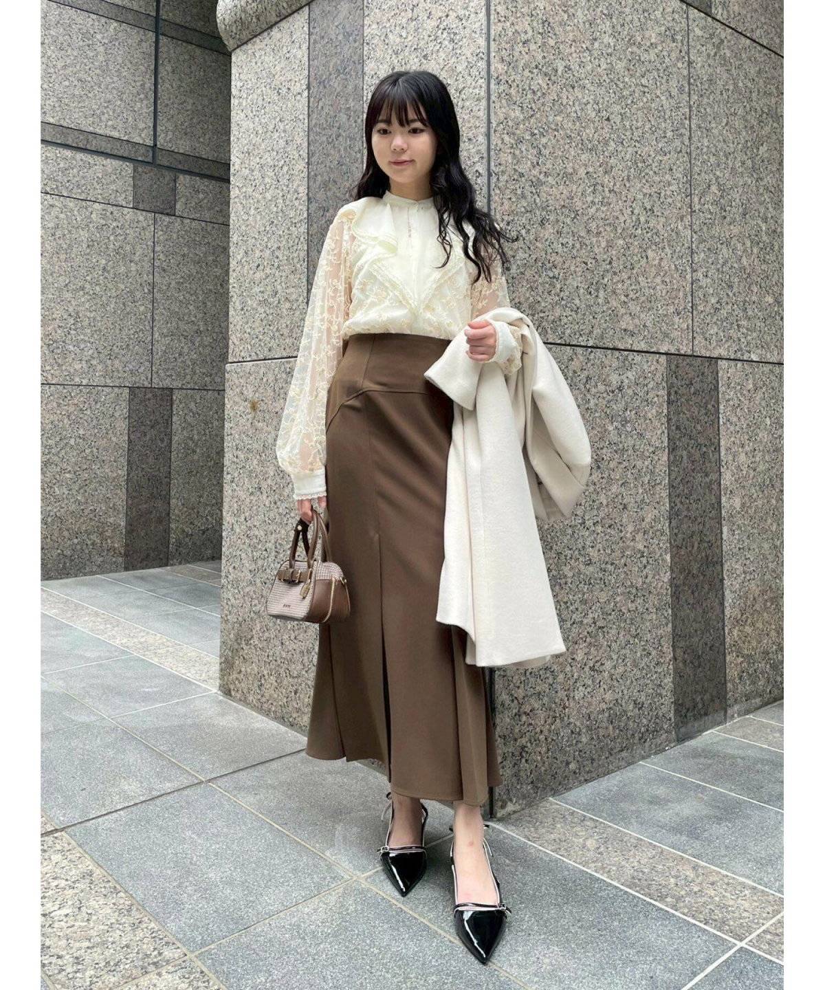 長袖トップスとマーメイドスカートを合わせた女性