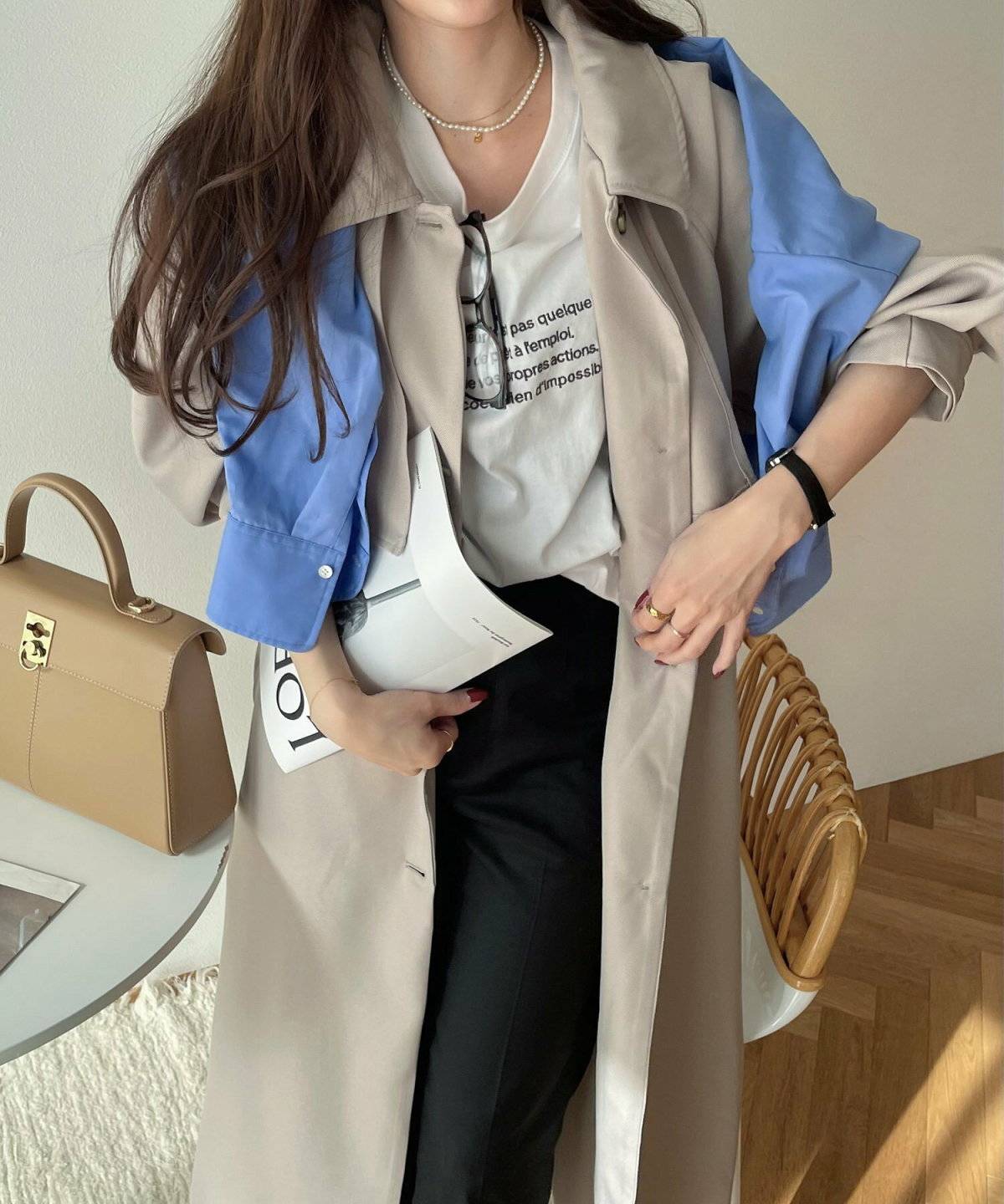 ロゴTシャツにトレンチコートを羽織った女性