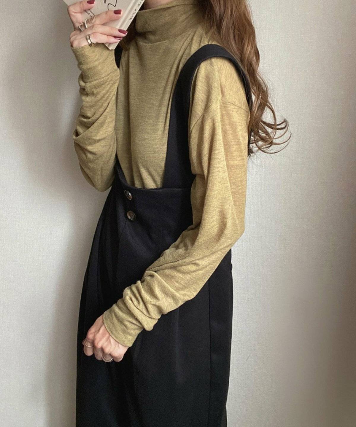 トップスに黒のサロペットを合わせた女性