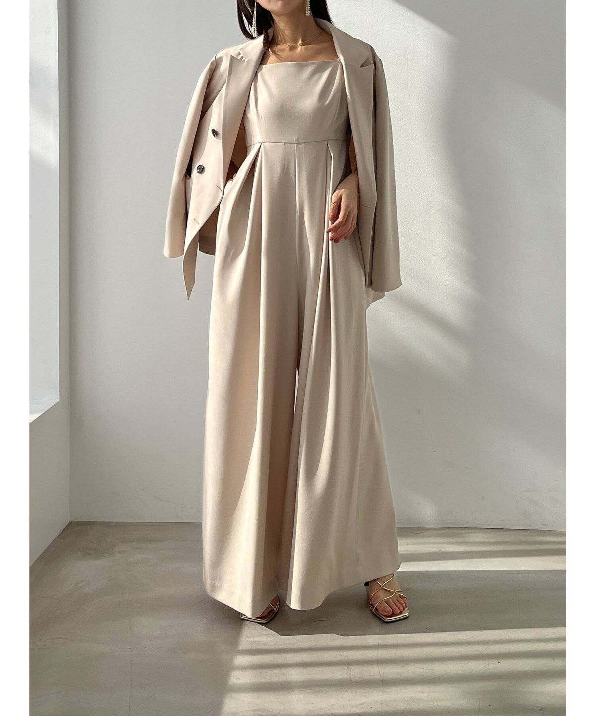 つなぎにジャケットを羽織った女性