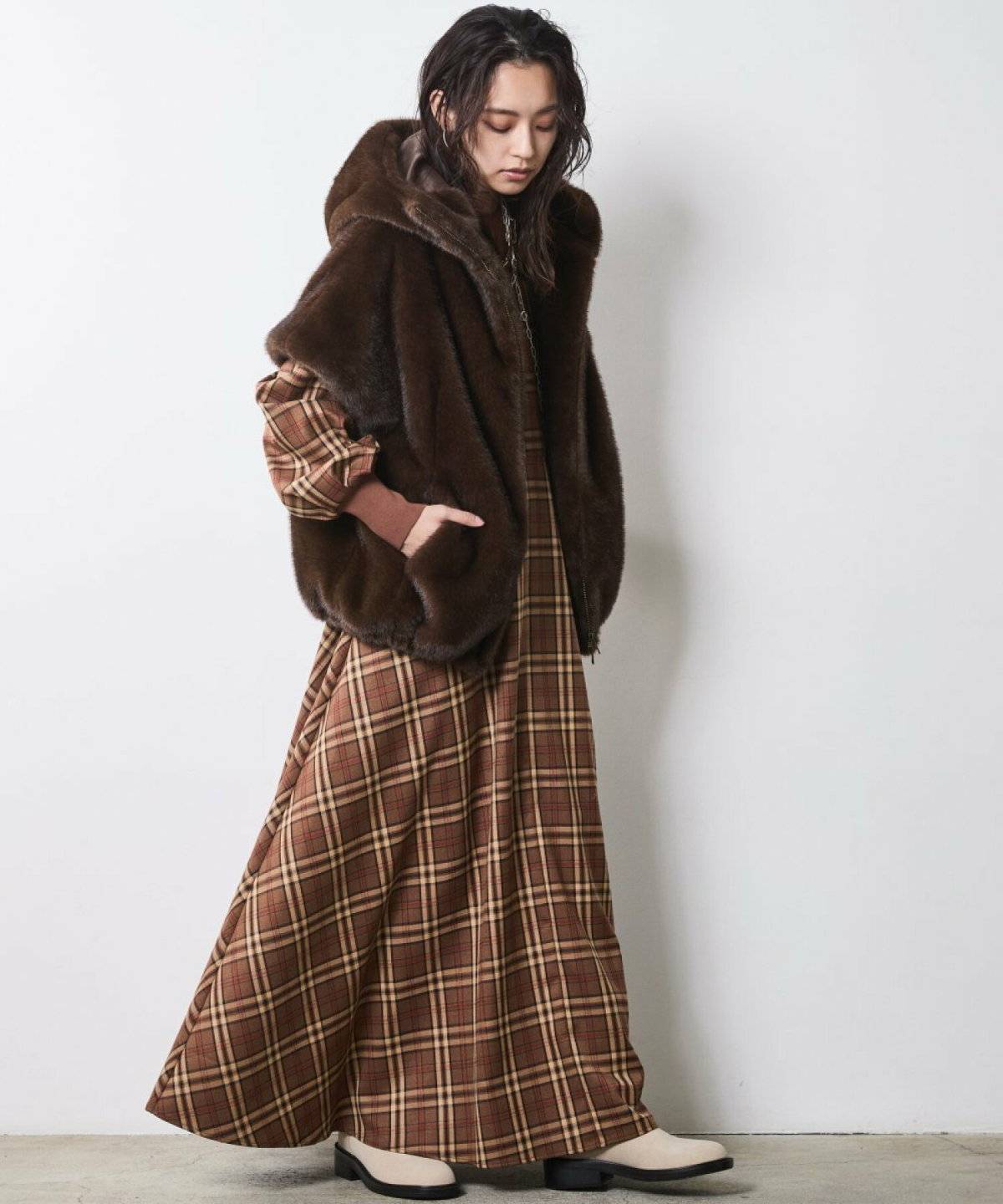 長袖ワンピースにファーベストを重ねた女性