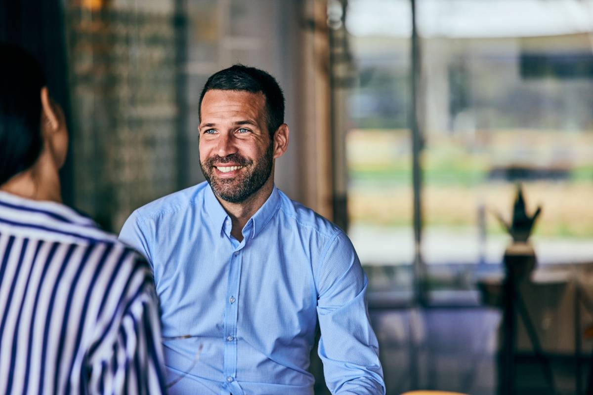 同僚の話を聞く男性
