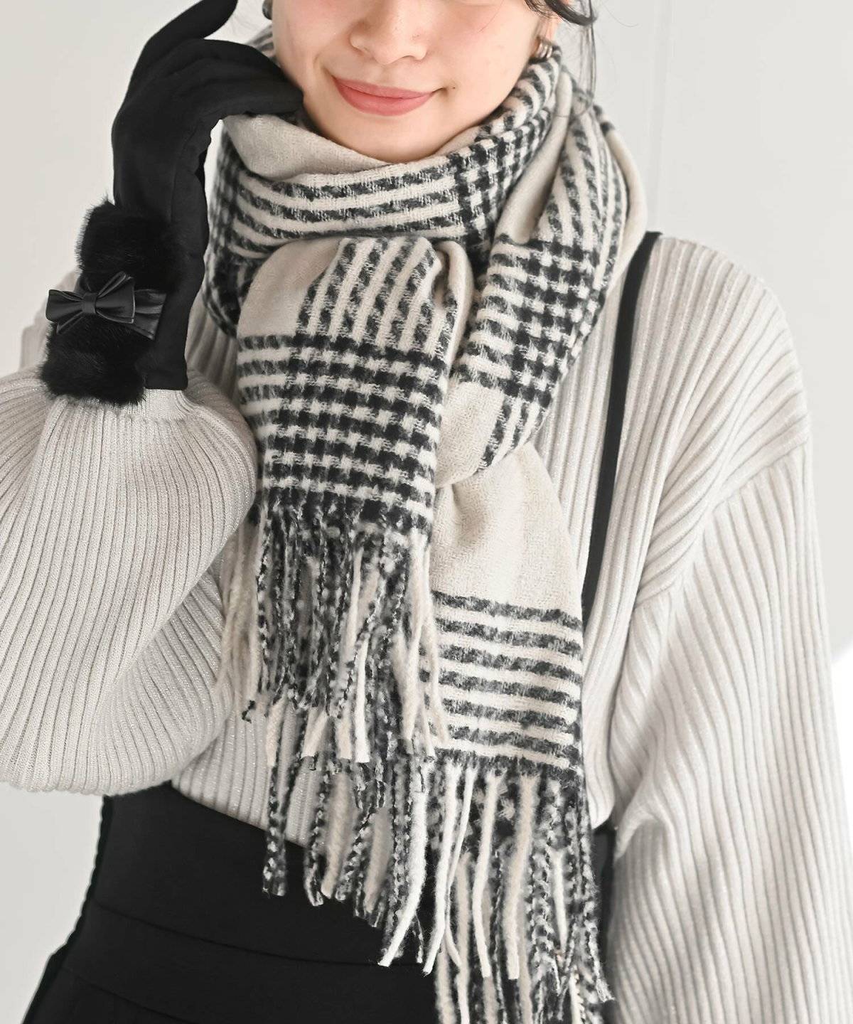 モノトーンコーデにチェック柄マフラーを巻いた女性