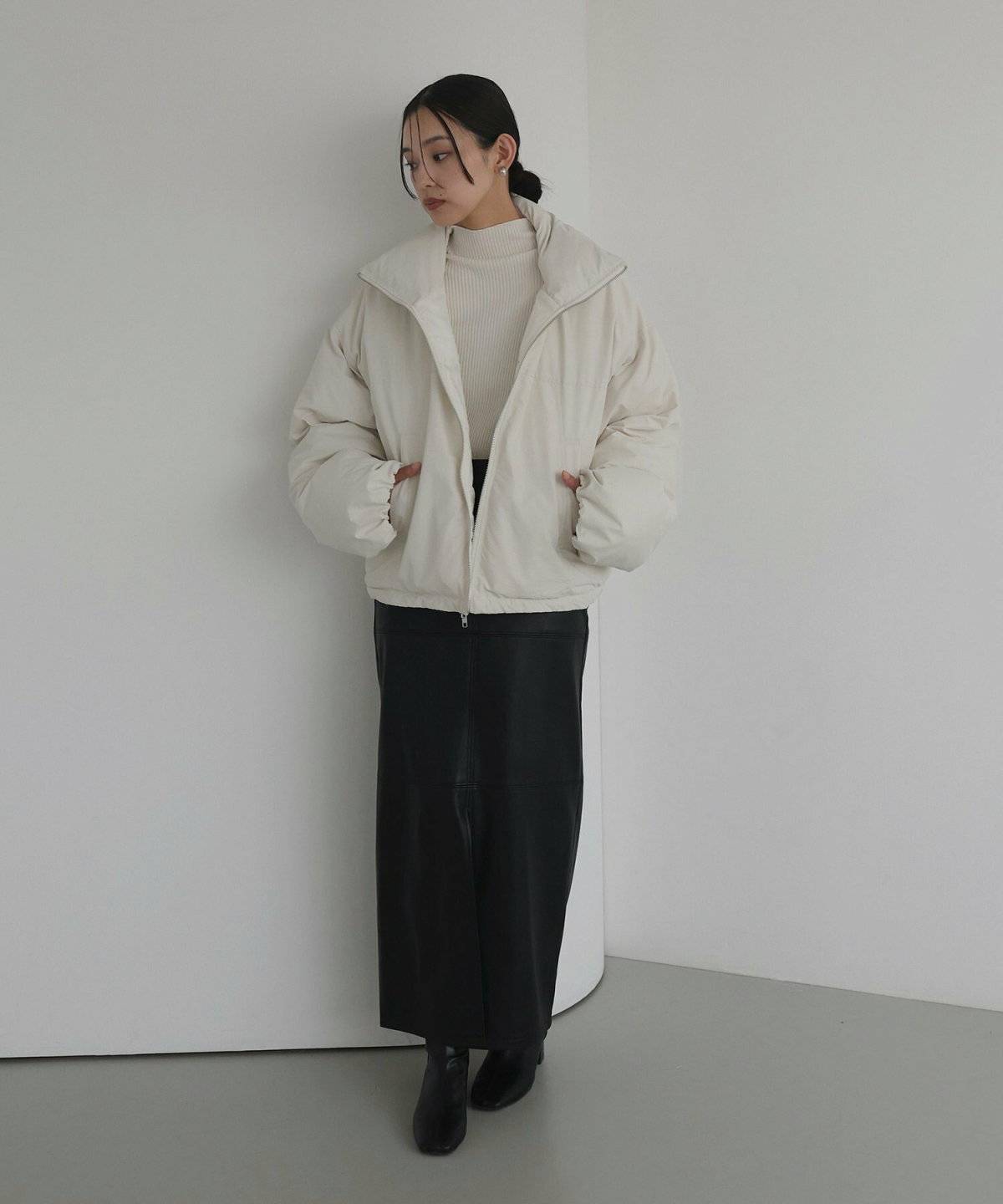 ホワイトコートに黒スカートを合わせた女性