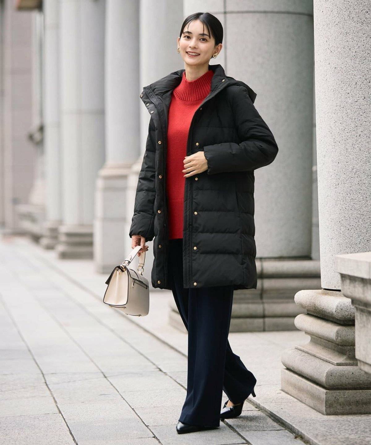 赤ニットにパンツを合わせた女性