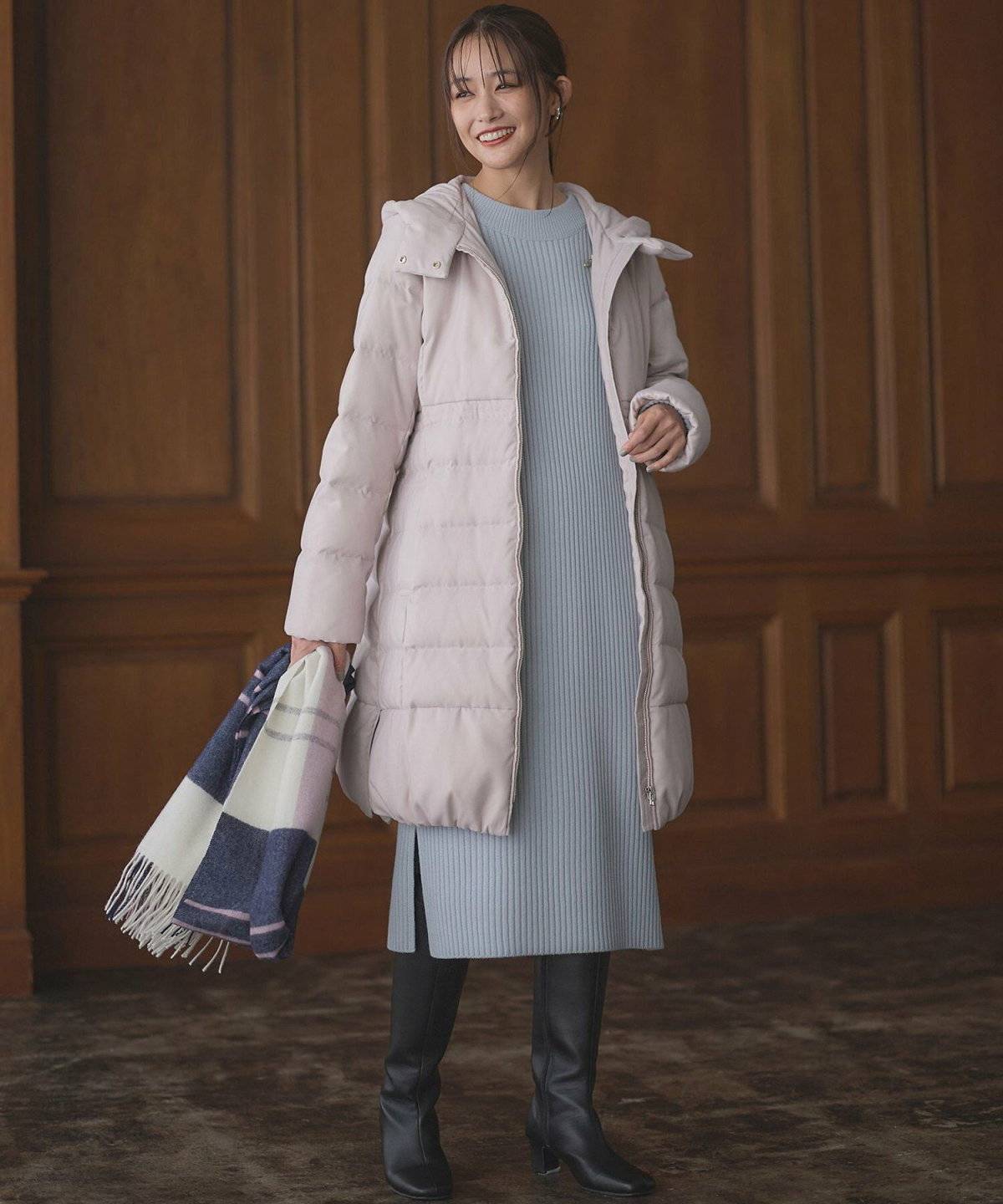 ブルーのワンピースにコートを羽織った女性