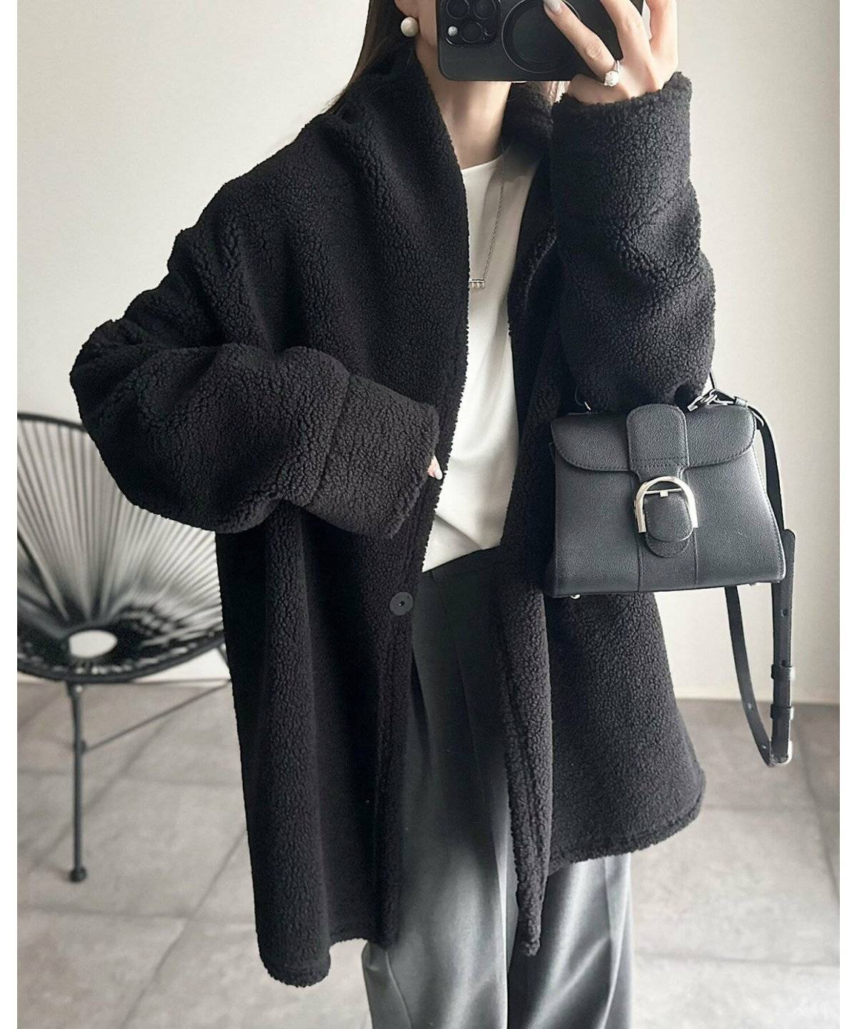 黒コートにグレーのパンツを合わせた女性