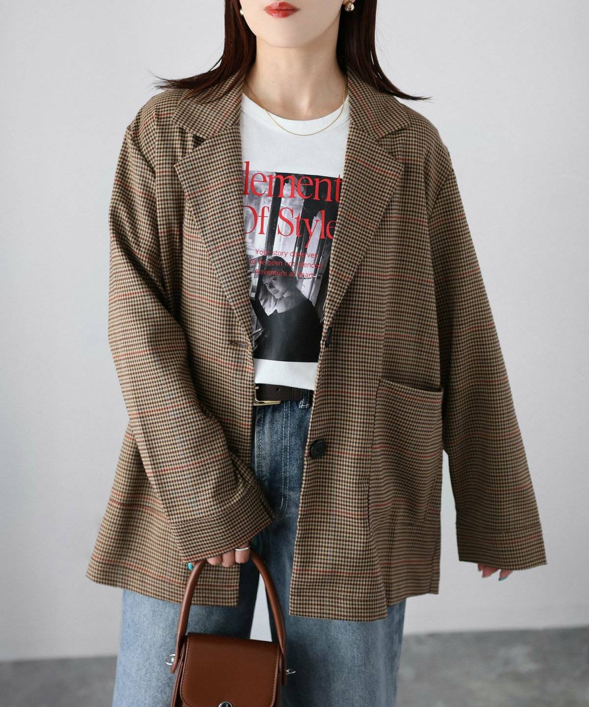 チェック柄ジャケットに黒デニムを合わせた女性