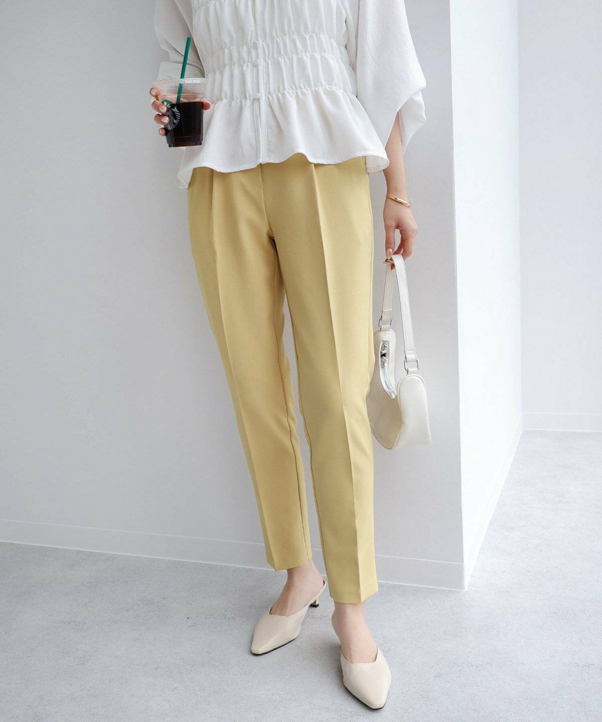 白ブラウスにイエローのパンツを合わせた女性