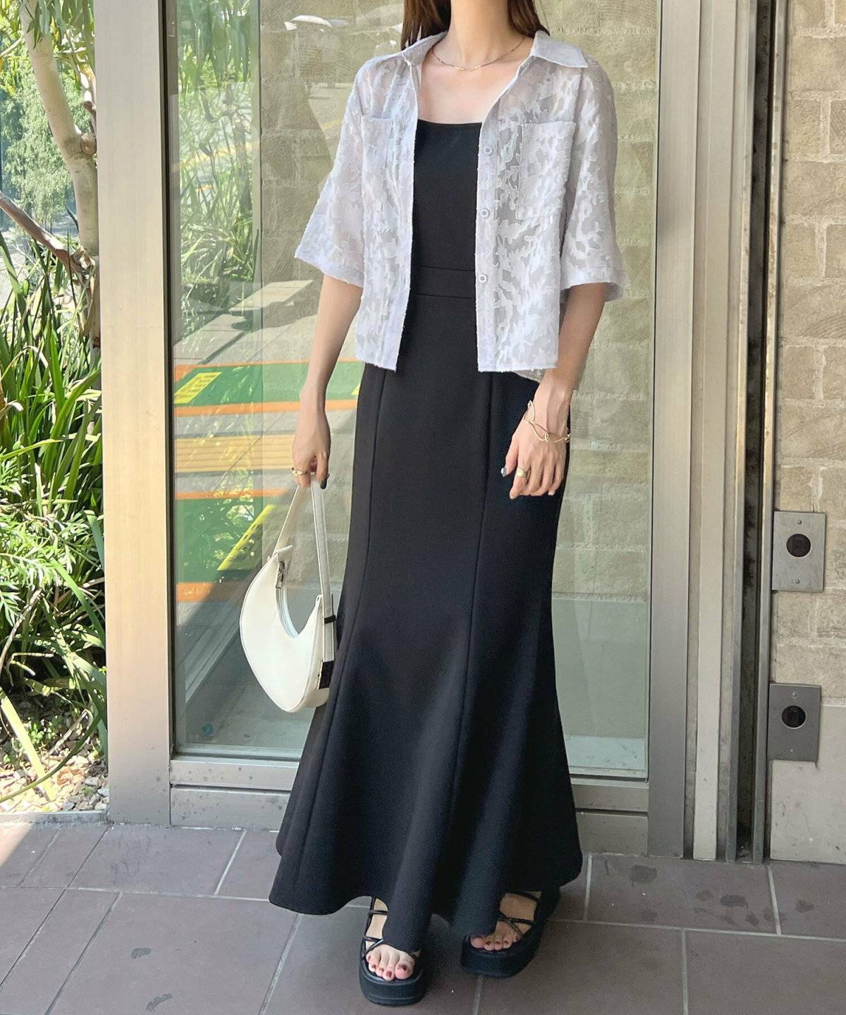 キャミワンピースに半そでシャツを羽織った女性