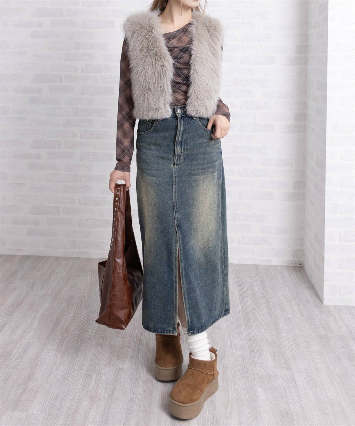 チェック柄ブラウスにファーベストを重ねた女性