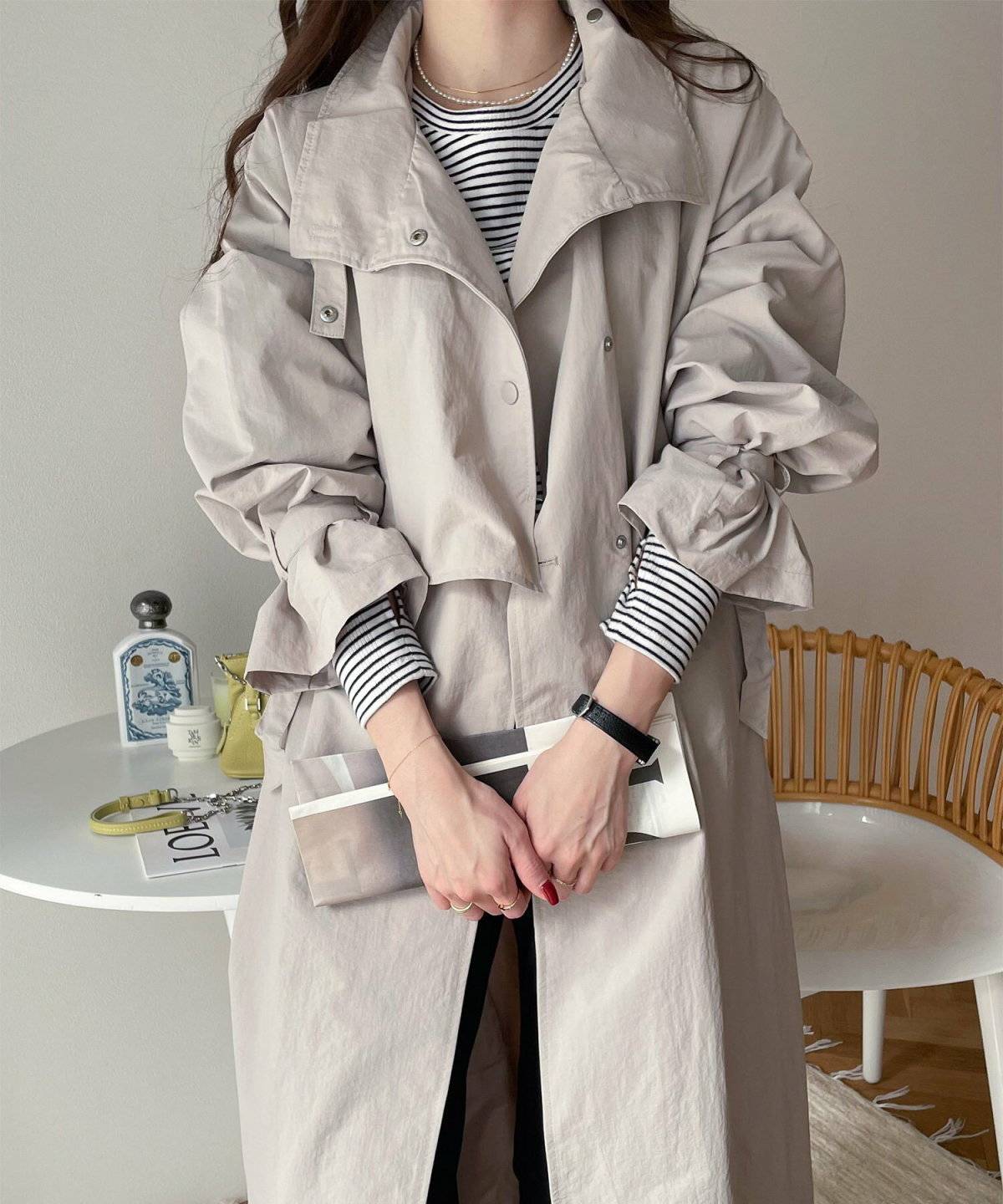 ボーダー柄トップスにトレンチコートを羽織った女性