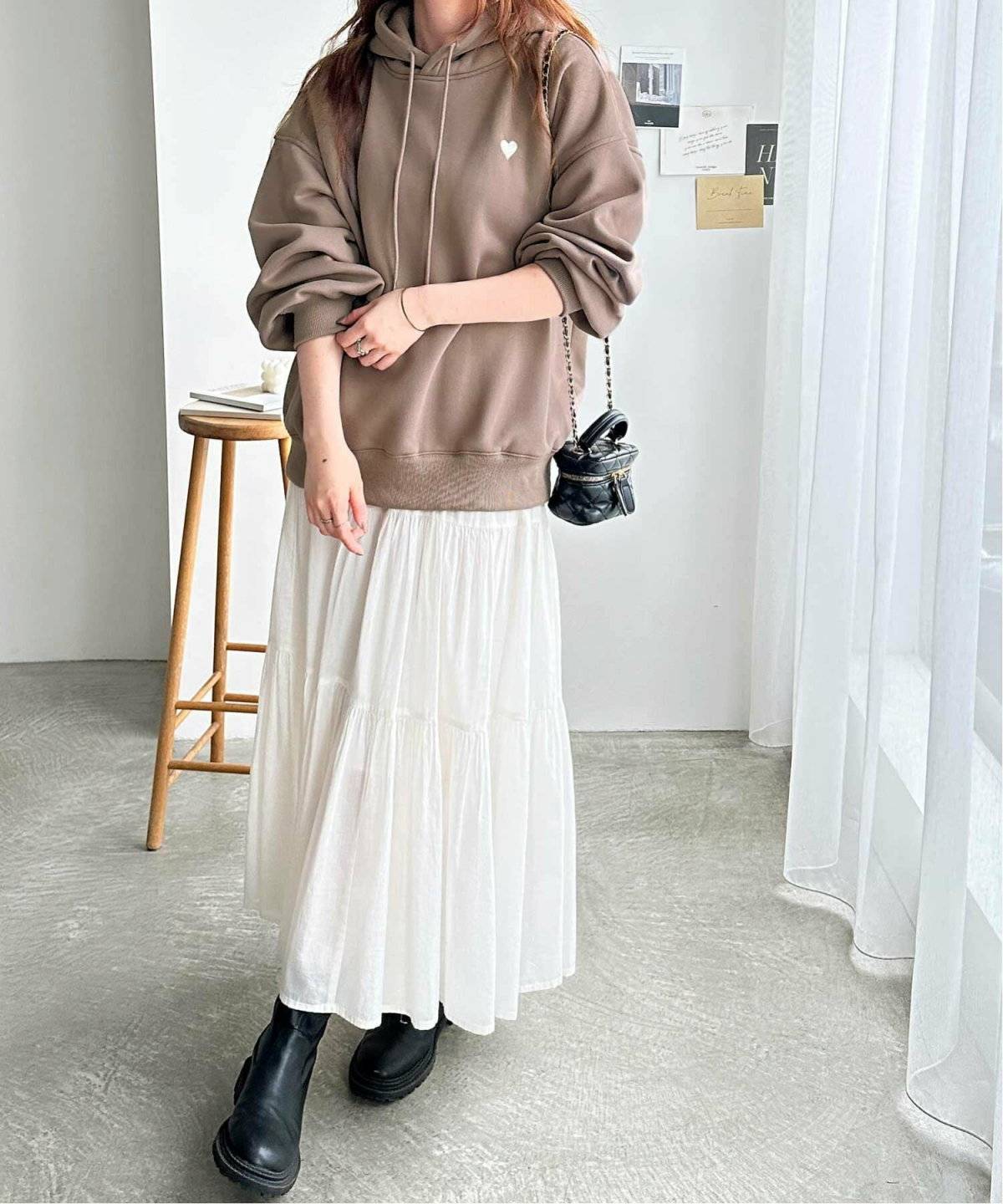 パーカーに白スカートを合わせた女性