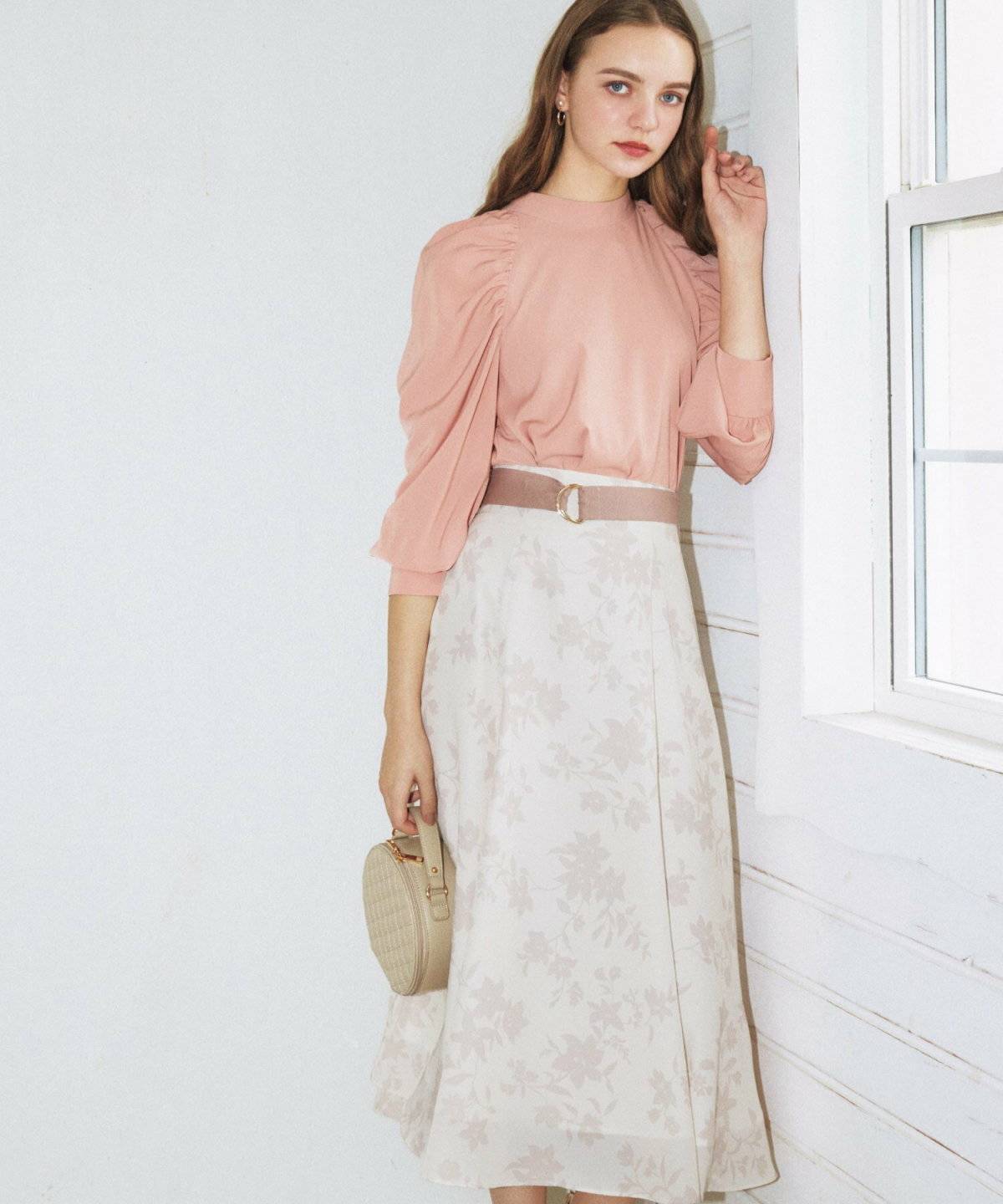 ブラウスに花柄スカートを合わせた女性
