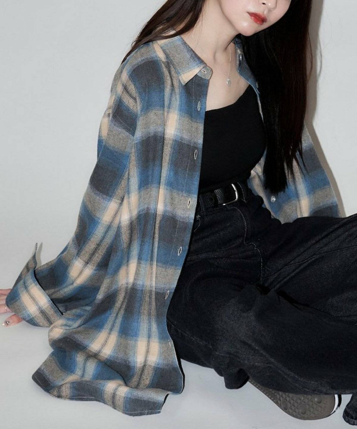 チェック柄シャツにブラックデニムを合わせた女性