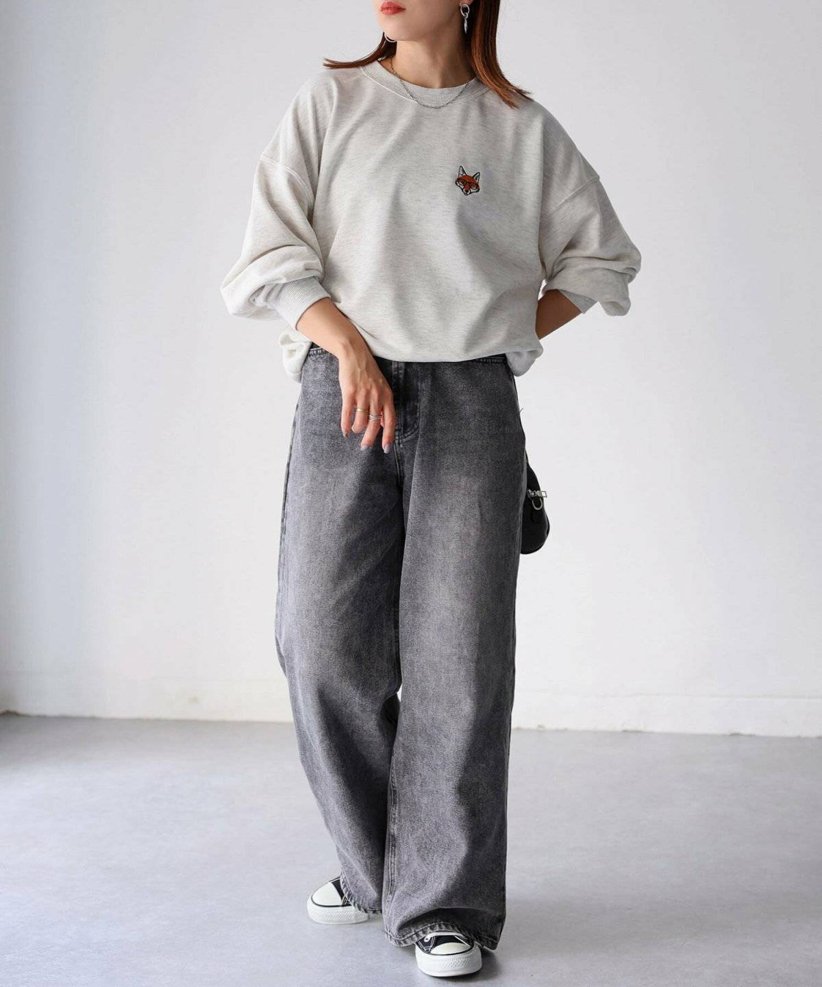 グレーのスウェットに黒パンツを合わせた女性