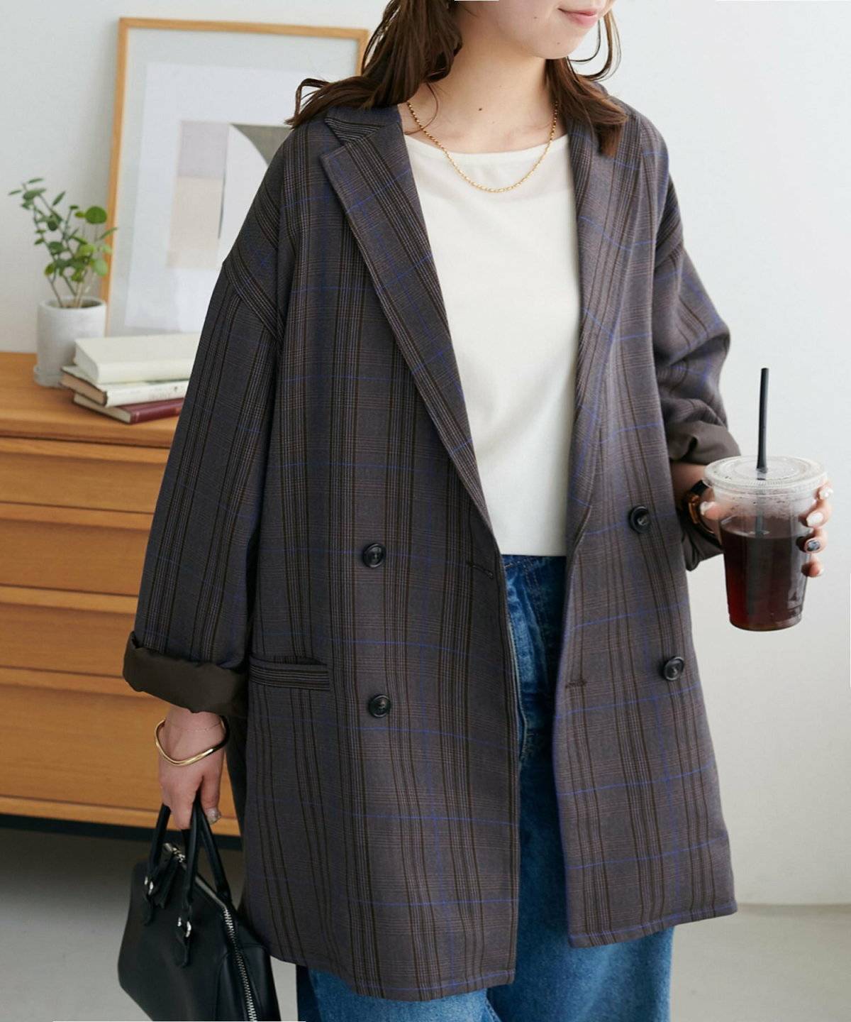 タンクトップにチェック柄ジャケットを羽織ってデニムを穿いた女性