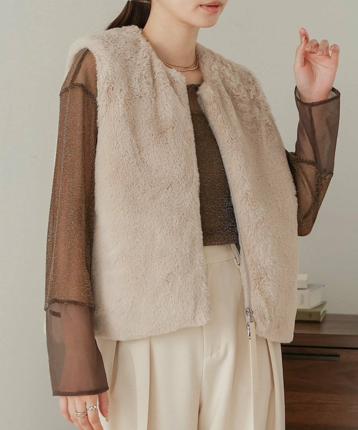 ベージュのファーベストを重ねた女性