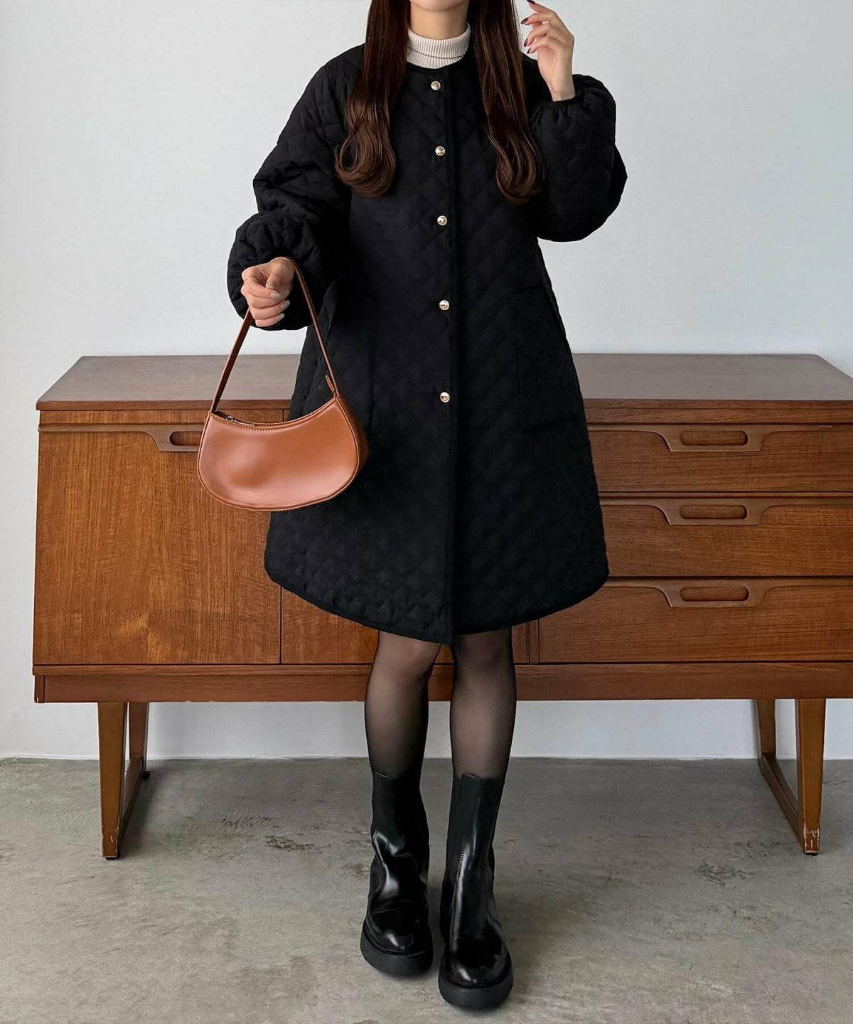 黒のキルティングコートを着た女性