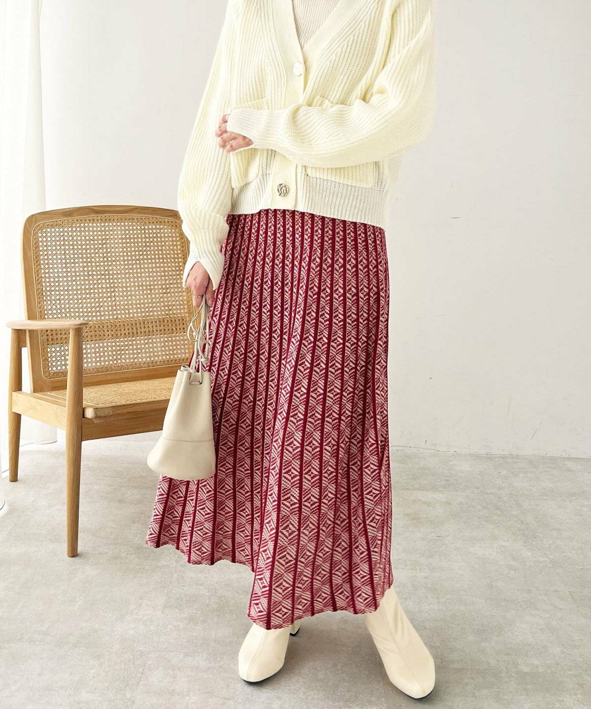 白ニットに赤スカートを合わせた女性
