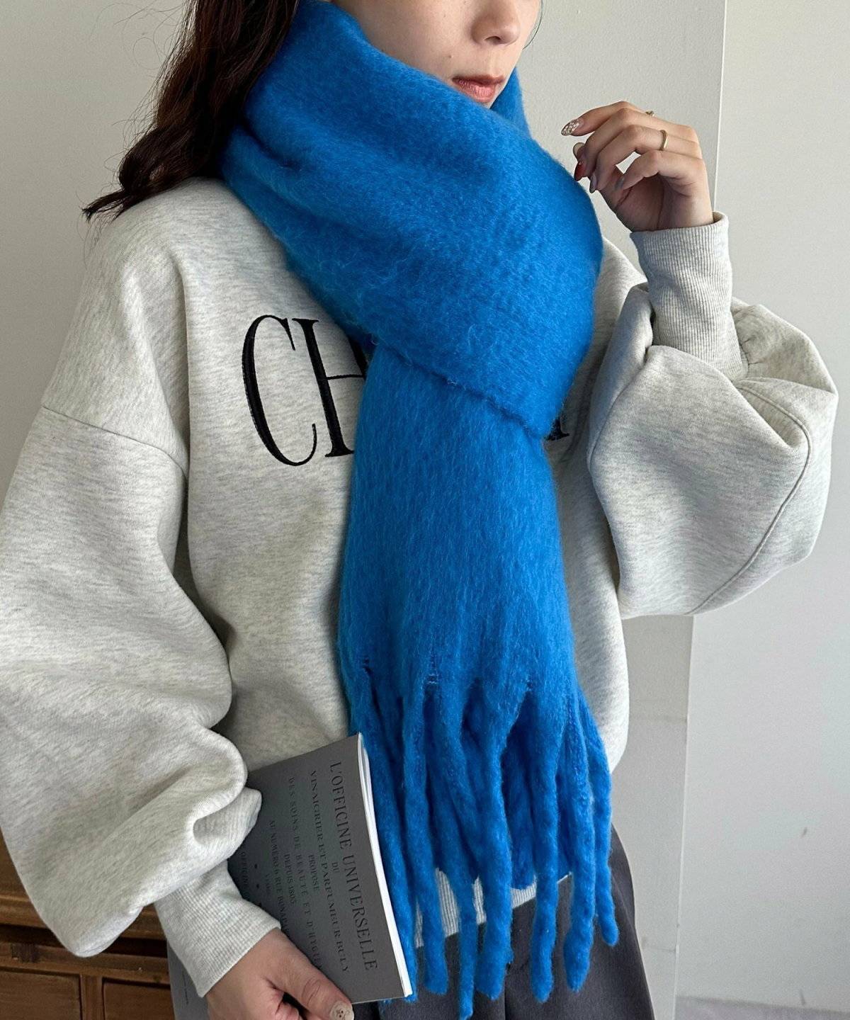 グレーのワントーンコーデにマフラーを巻いた女性