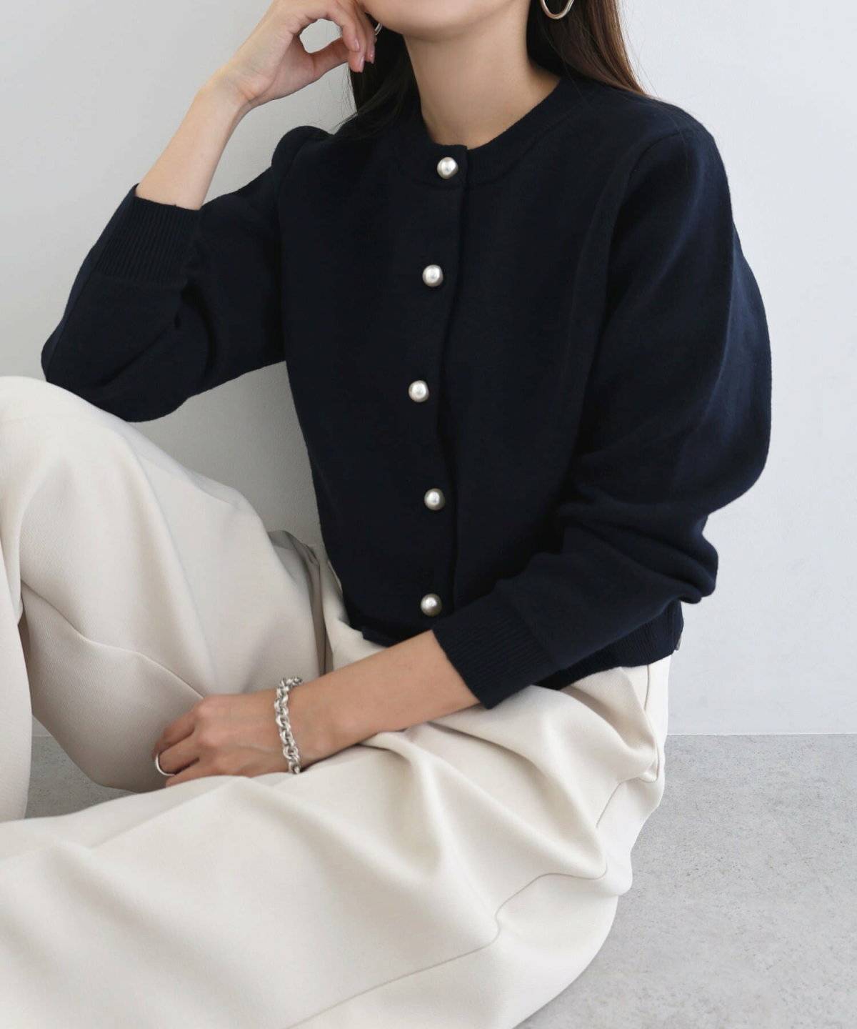 ネイビーのニットにパンツを合わせた女性