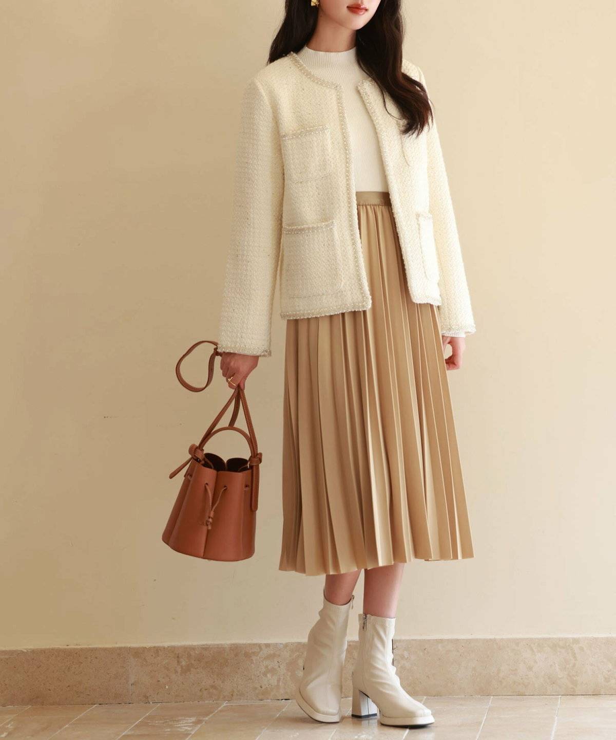 ツイードジャケットにスカートを合わせた女性