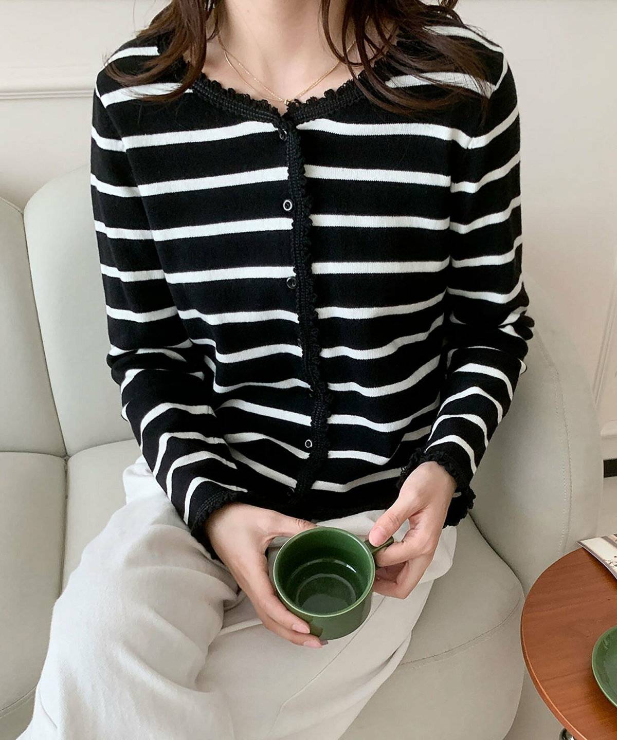 ボーダー柄カーディガンにパンツを合わせた女性