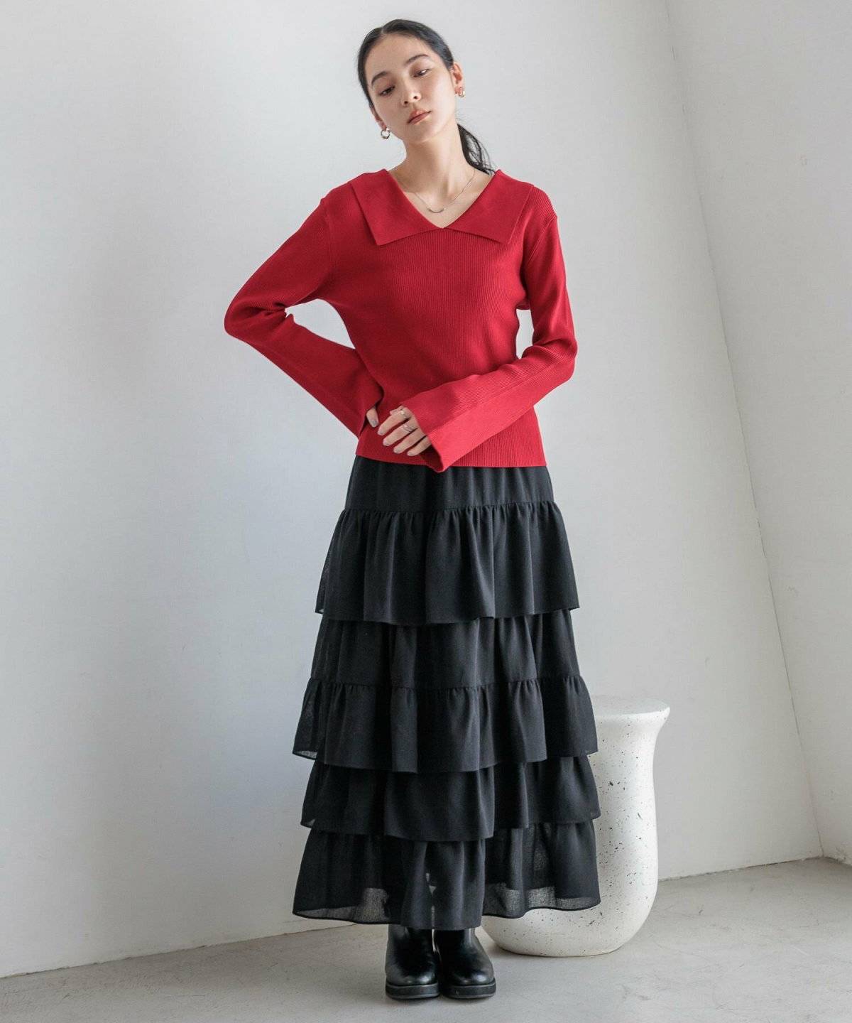 赤ニットに黒スカートを合わせた女性