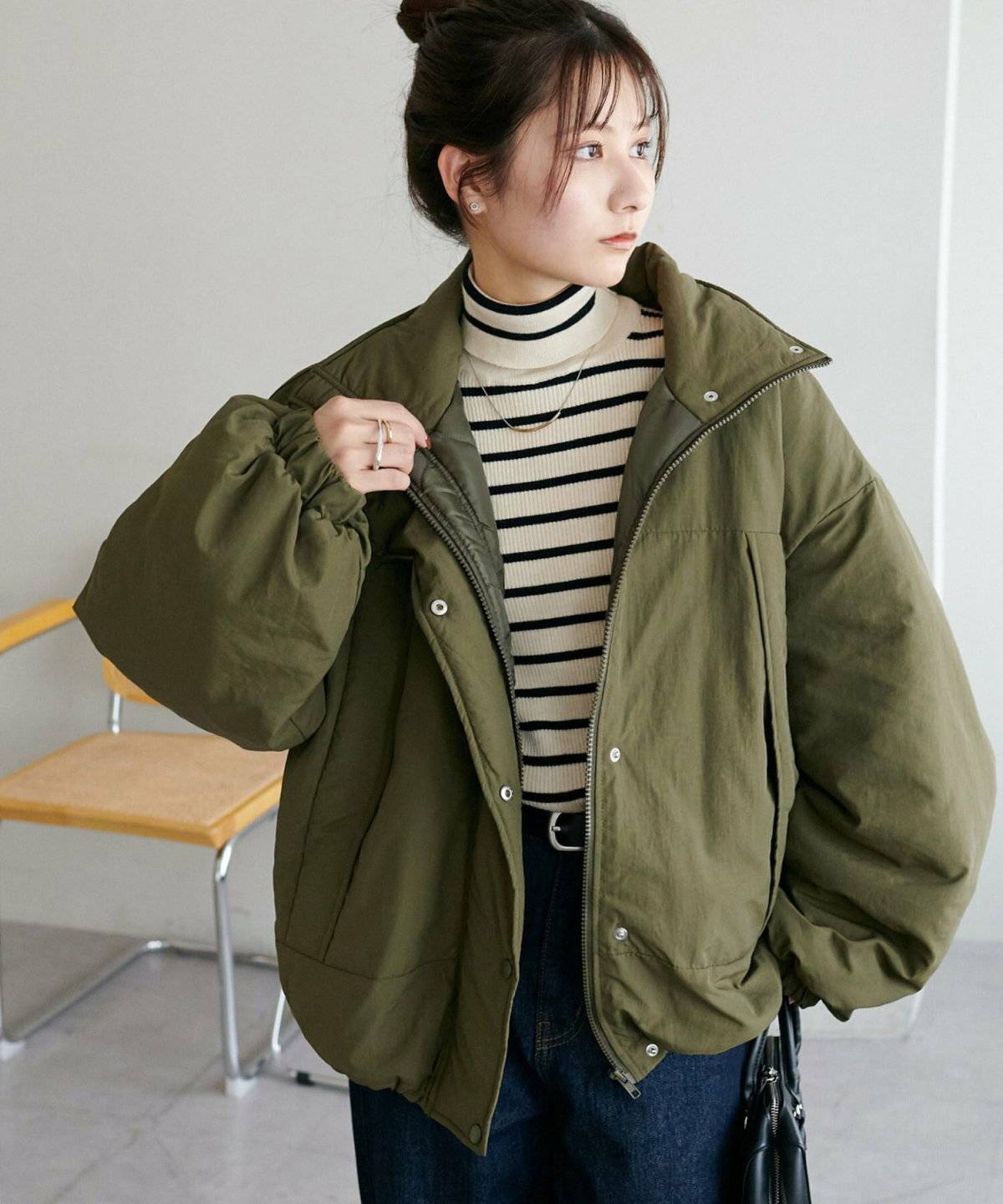 ボーダー柄トップスにカーキのブルゾンを羽織った女性