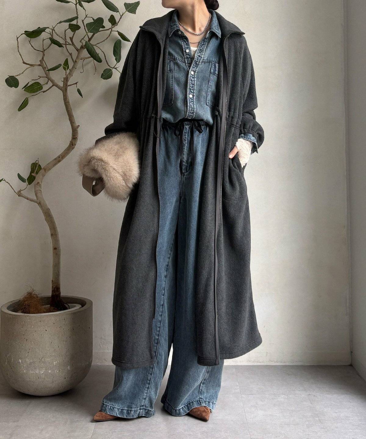 デニムジャケットにコートを羽織った女性