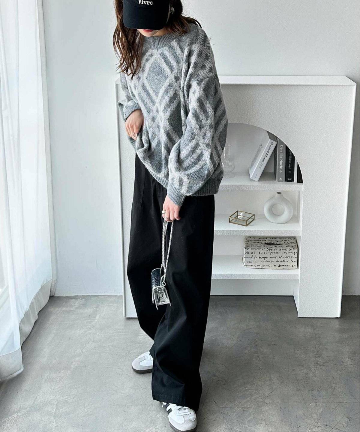 ブラックコーデにチェック柄ニットを合わせた女性