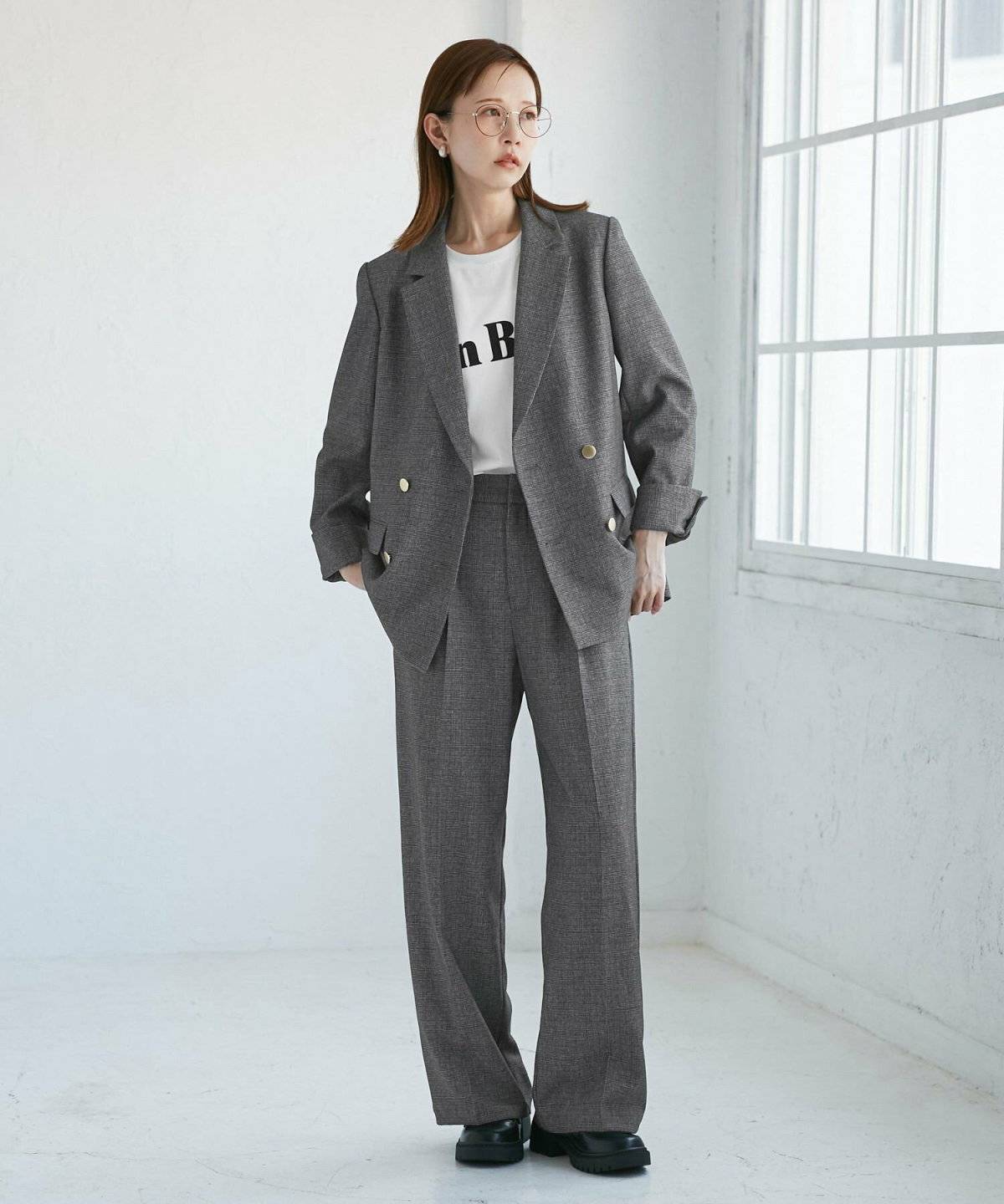 グレーのスーツにプリントTシャツを合わせた女性