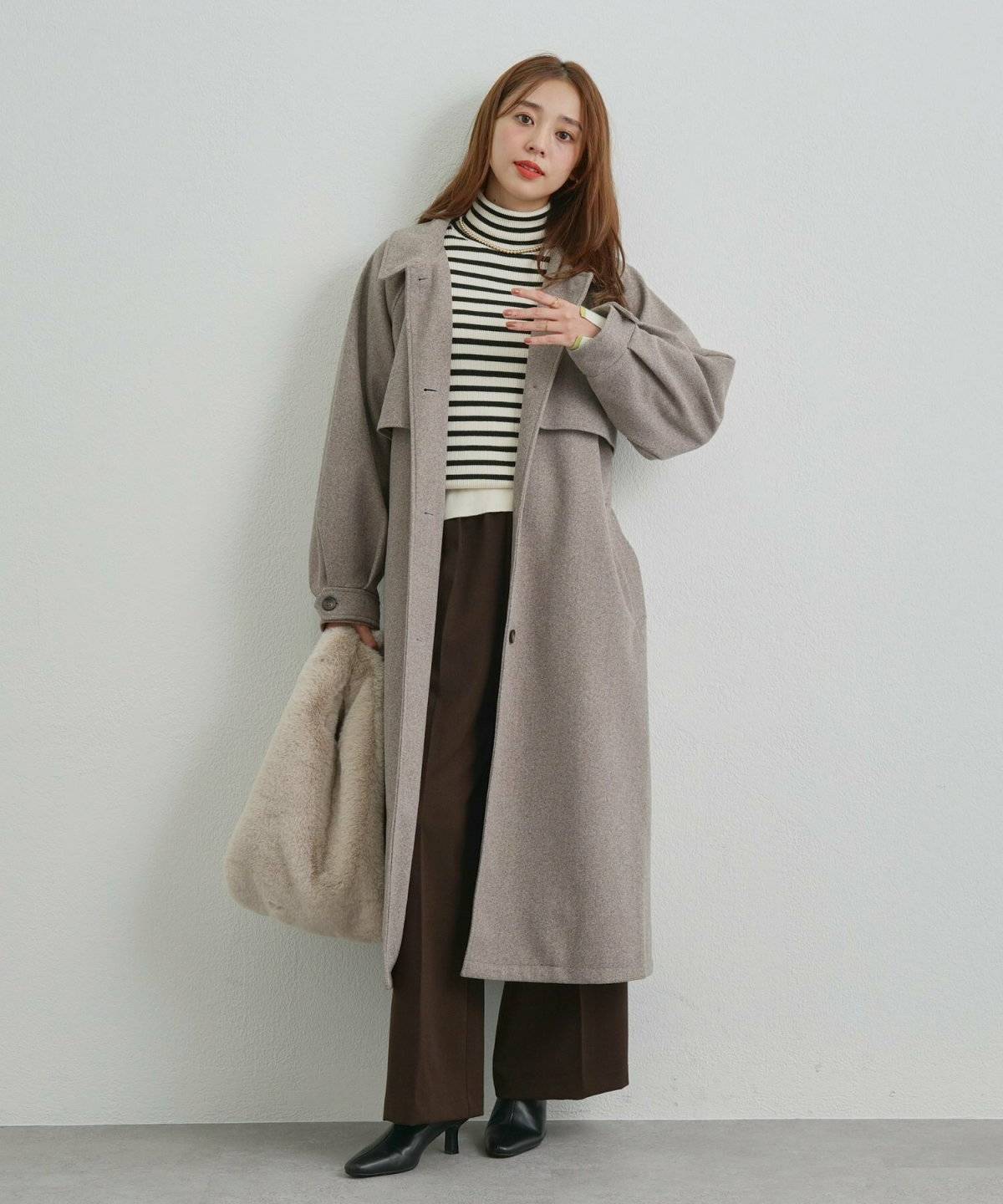 ボーダー柄ニットにパンツを合わせた女性