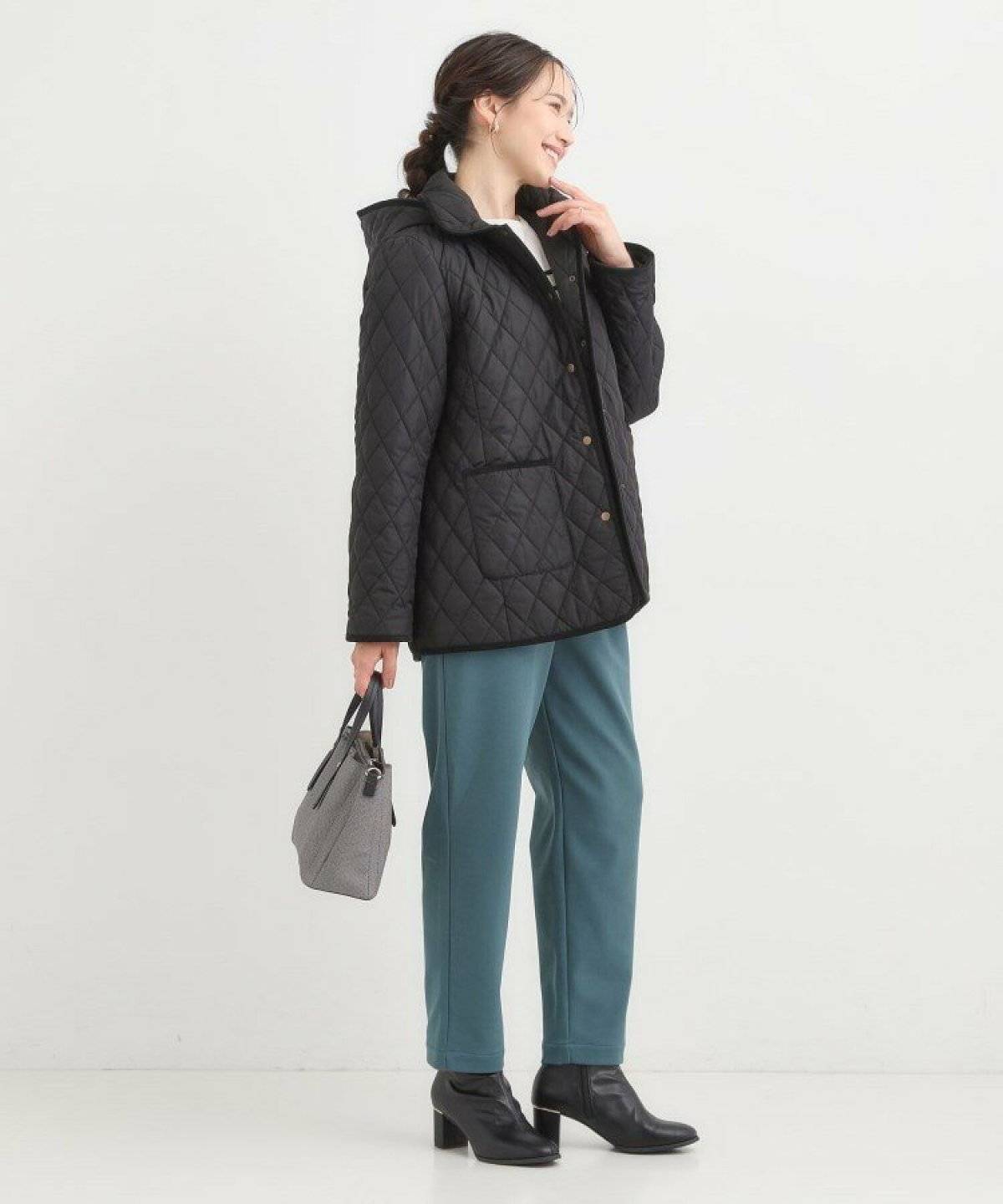 黒ジャケットにカラーパンツを合わせた女性